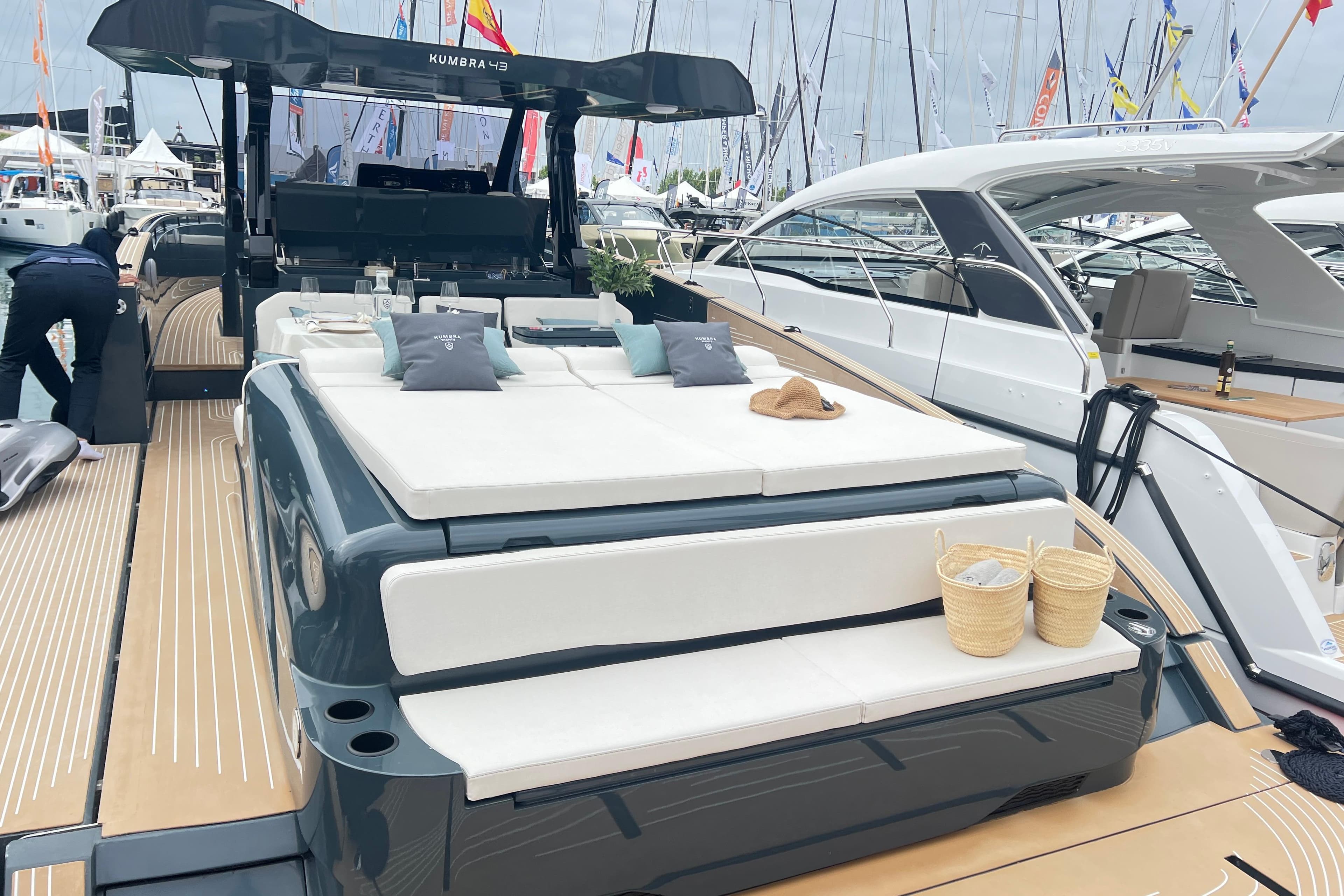 Luxurious 2026 Kumbra 43 yacht with sunbathing deck at a marina exhibition.