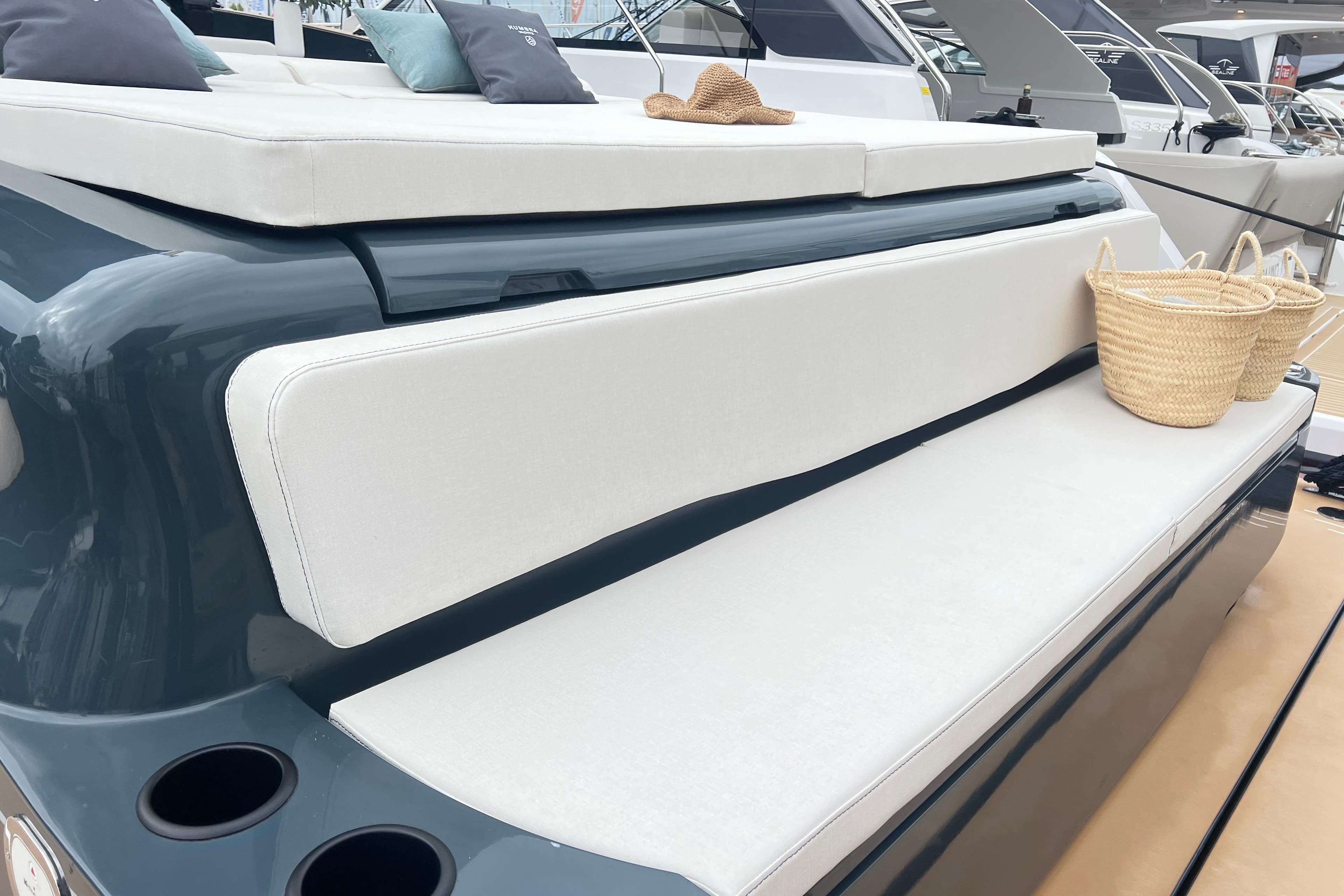 Luxury seating area on 2026 Kumbra 43 yacht with cushions and wicker basket.
