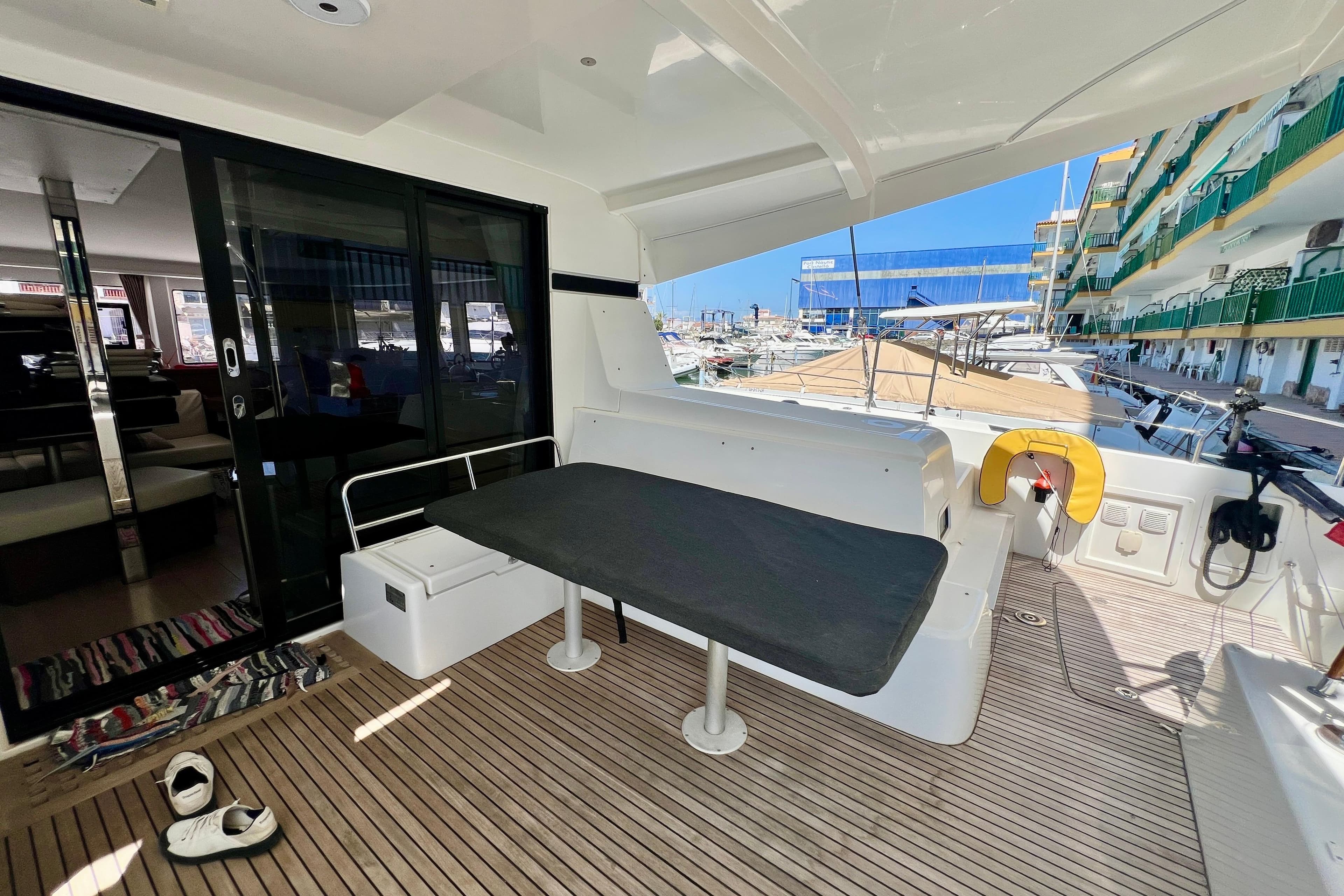 Spacious deck of a 2019 Lagoon 42 catamaran with seating and marina view.