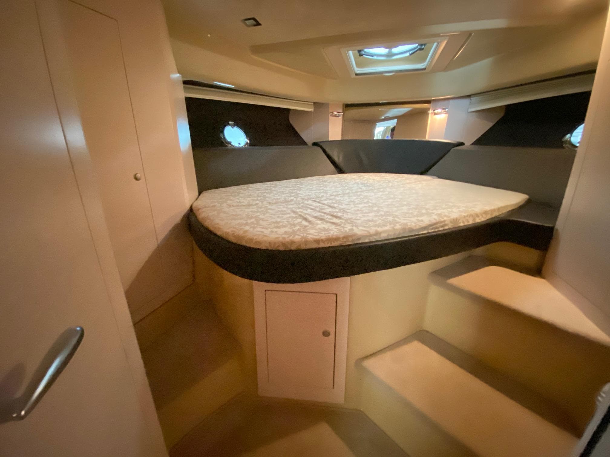 Interior cabin of 2012 Cranchi M38 yacht with bed and portholes.