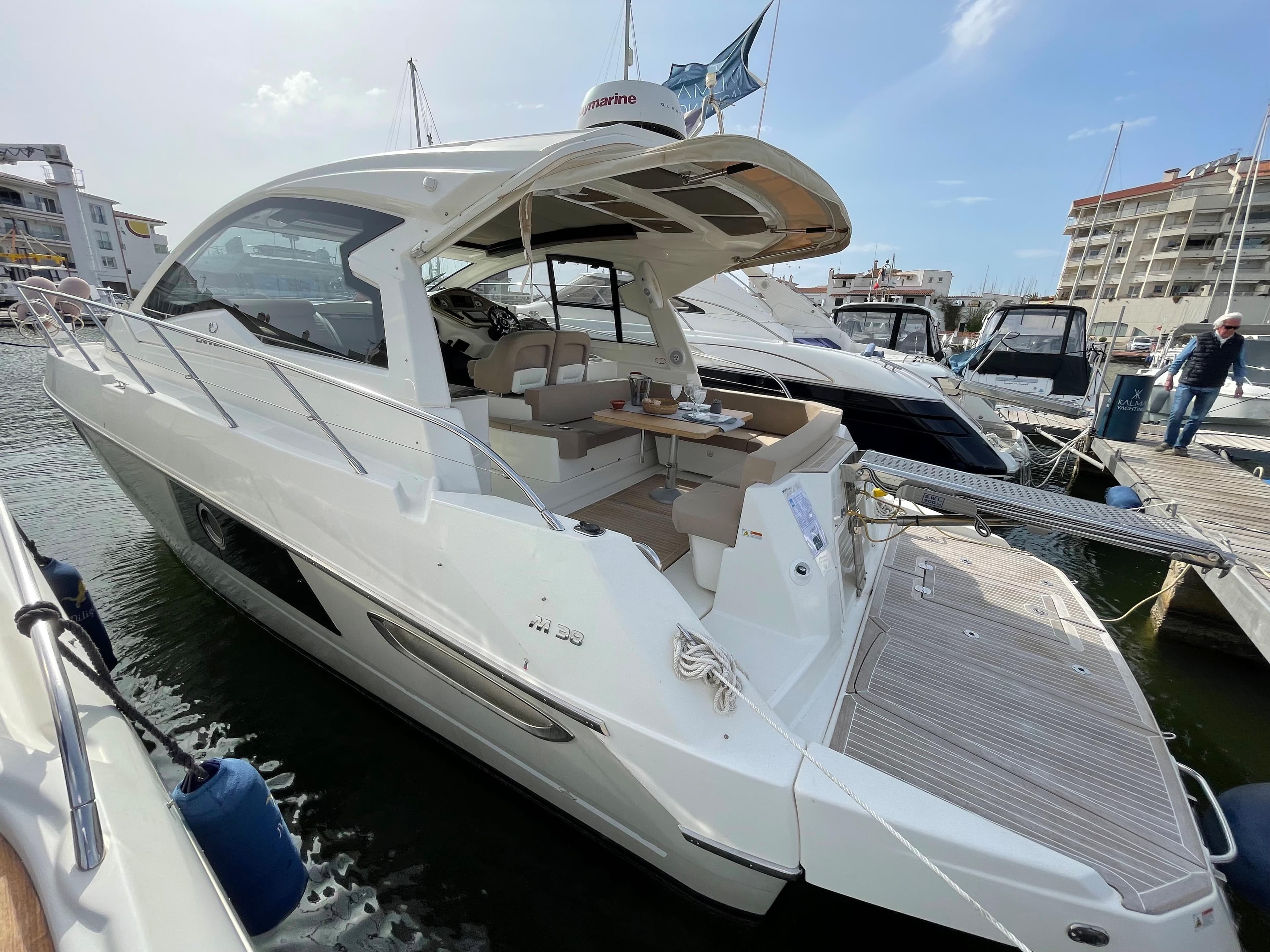 2012 Cranchi M38 yacht docked at marina, featuring sleek design and spacious deck area.