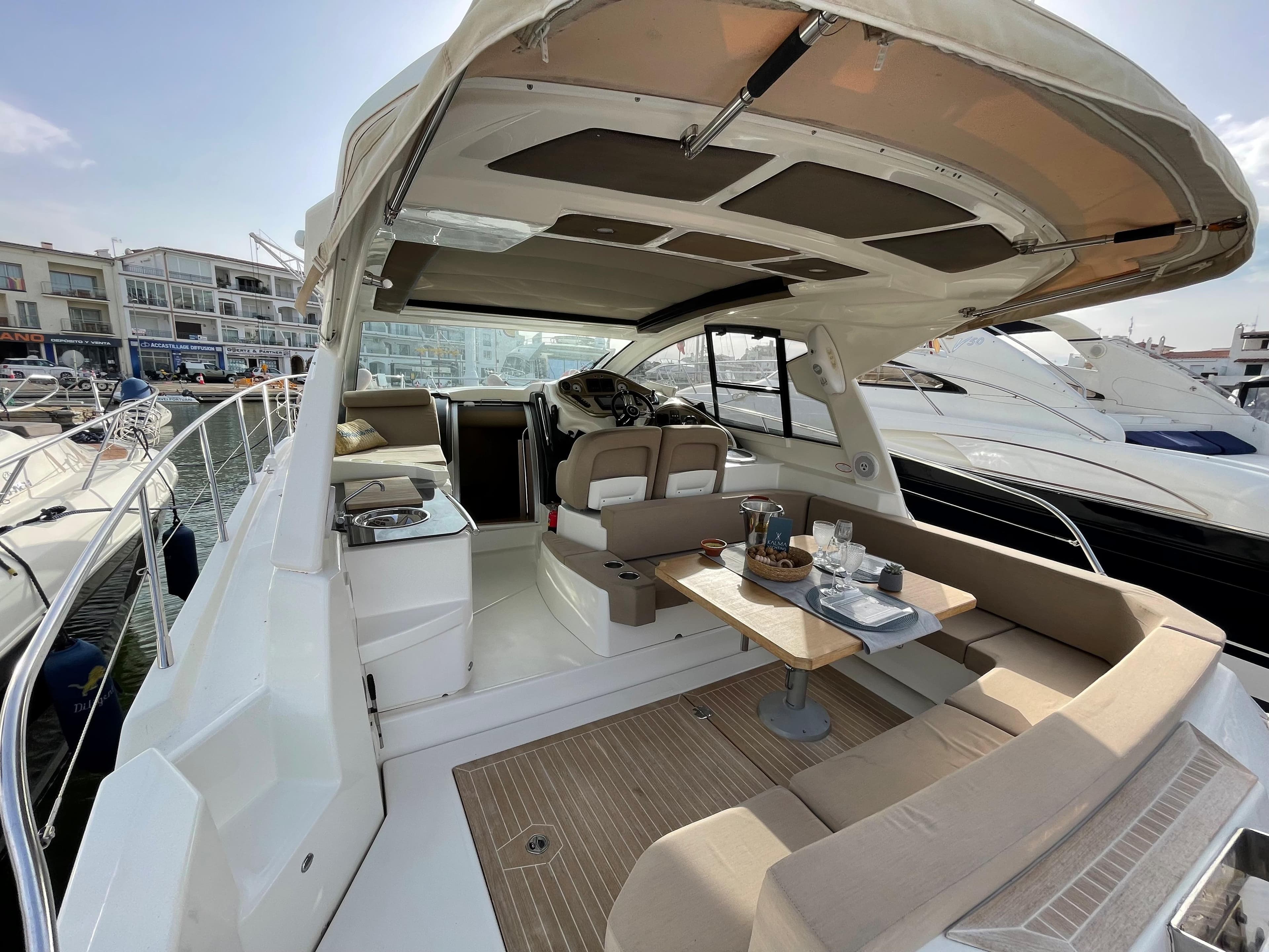 2012 Cranchi M38 yacht with spacious deck, seating, and dining area in a marina setting.