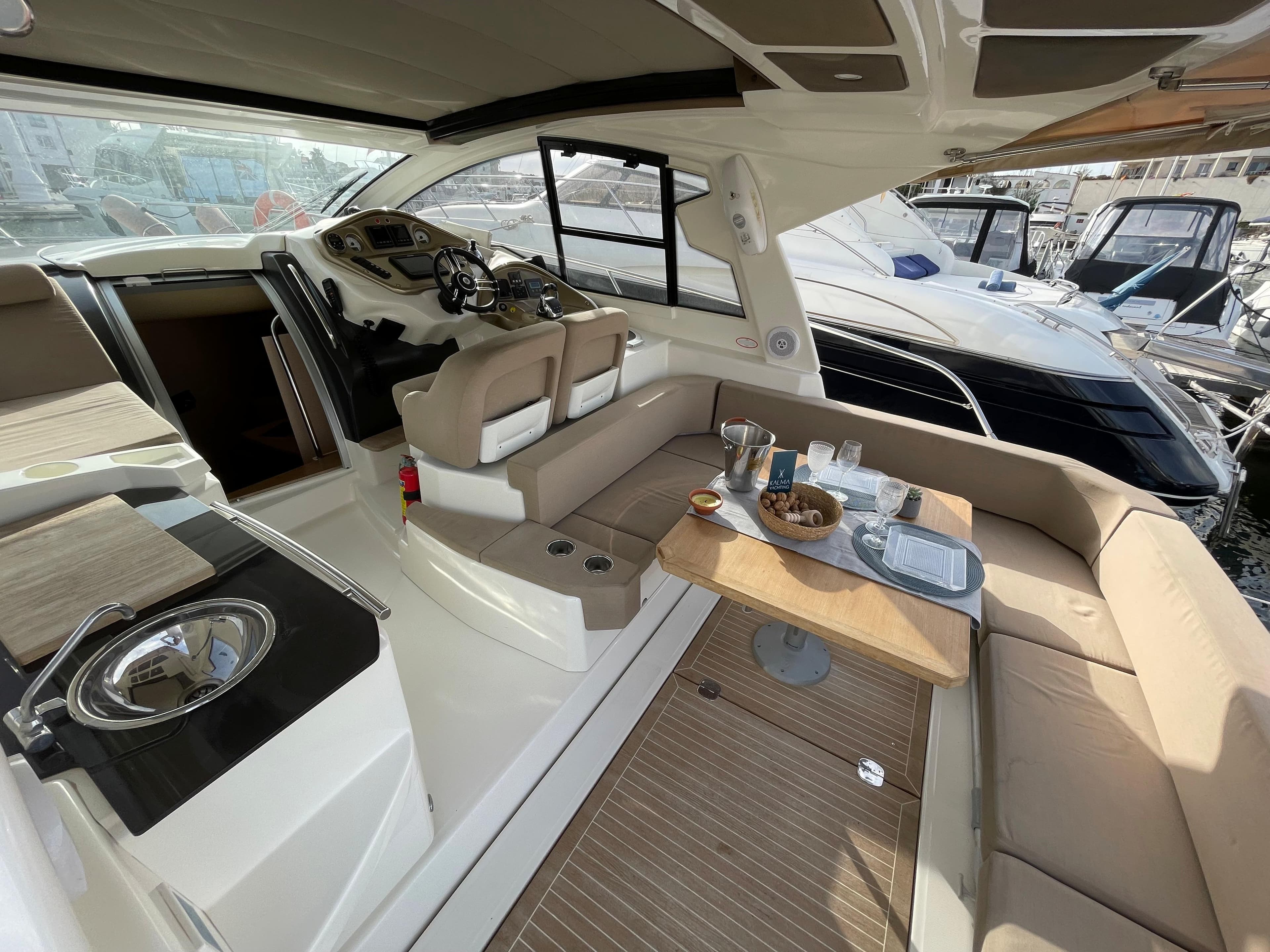Interior of 2012 Cranchi M38 yacht with seating, table, and helm station.