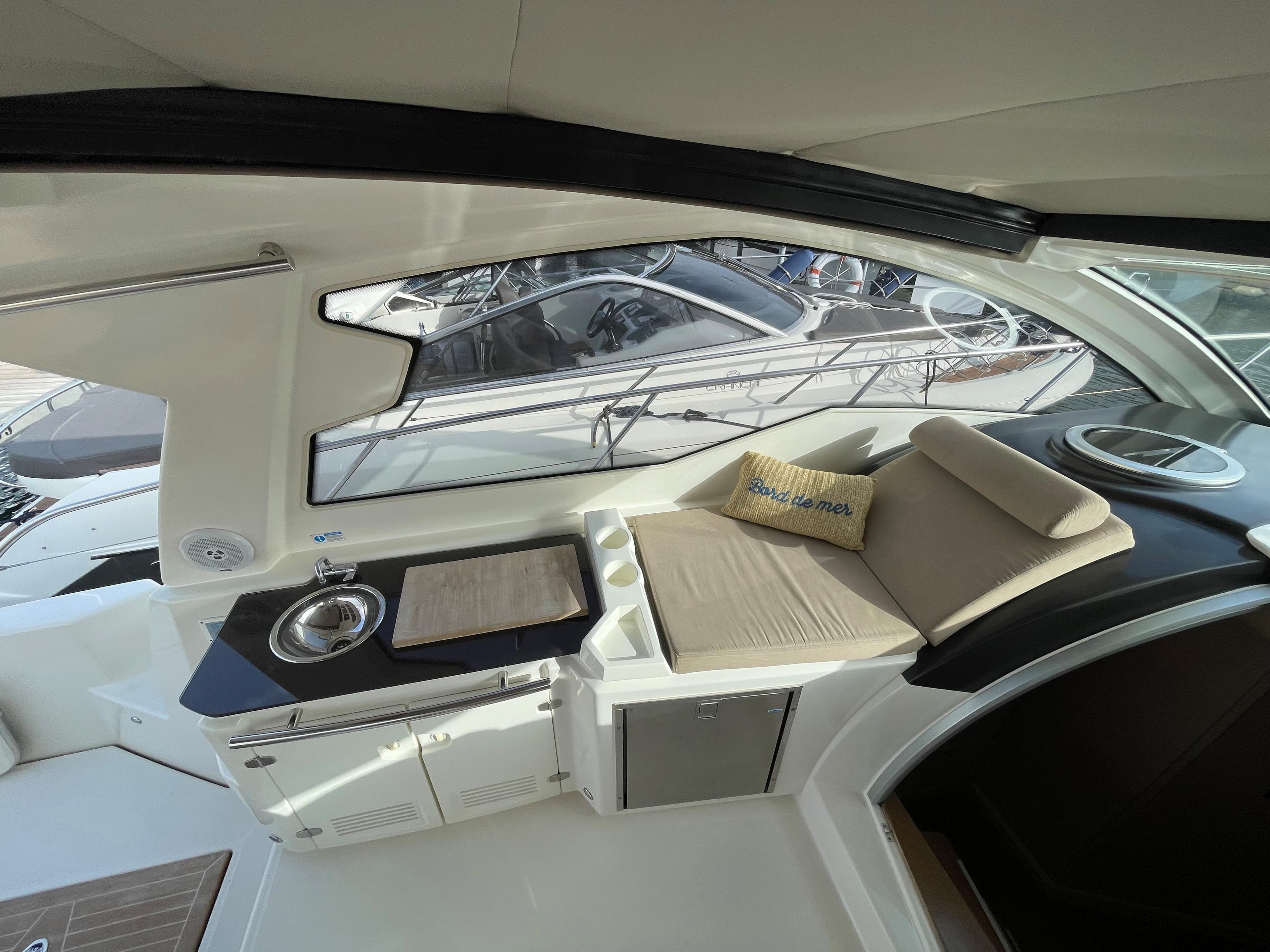 Interior view of 2012 Cranchi M38 yacht with seating and kitchenette.