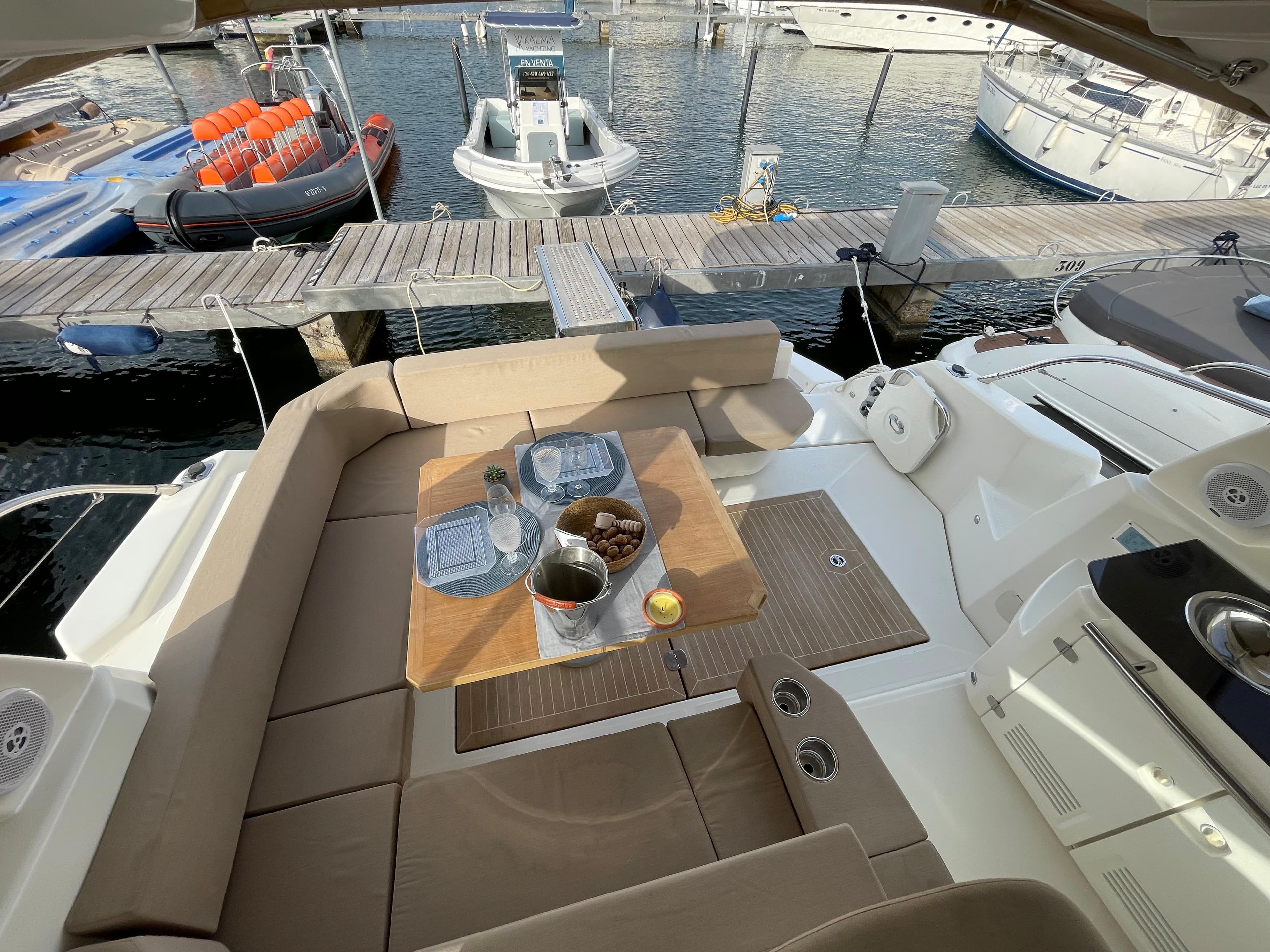 2012 Cranchi M38 yacht interior with dining setup, docked at marina.