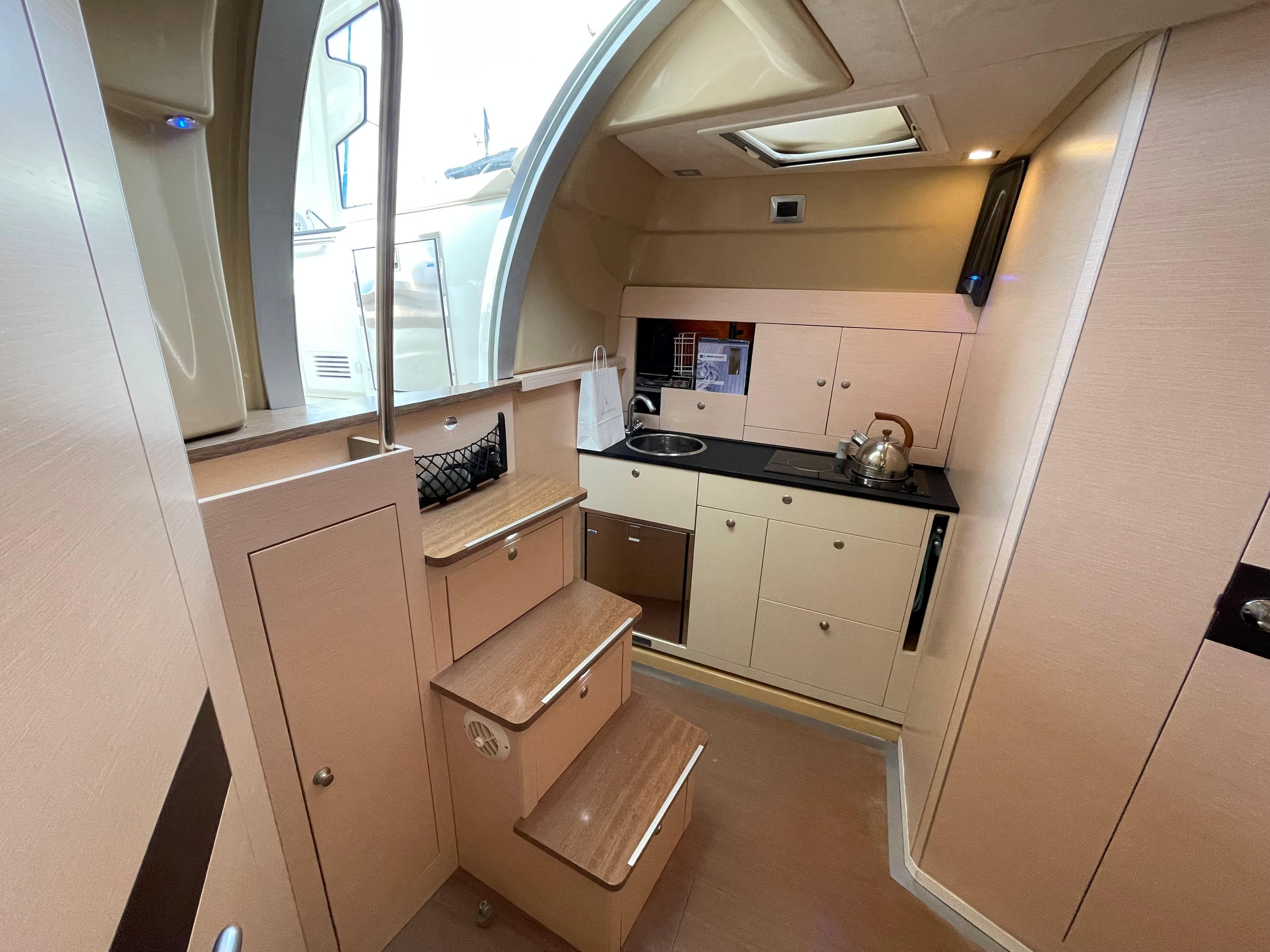 Interior of 2012 Cranchi M38 yacht, featuring compact kitchen and stairs.