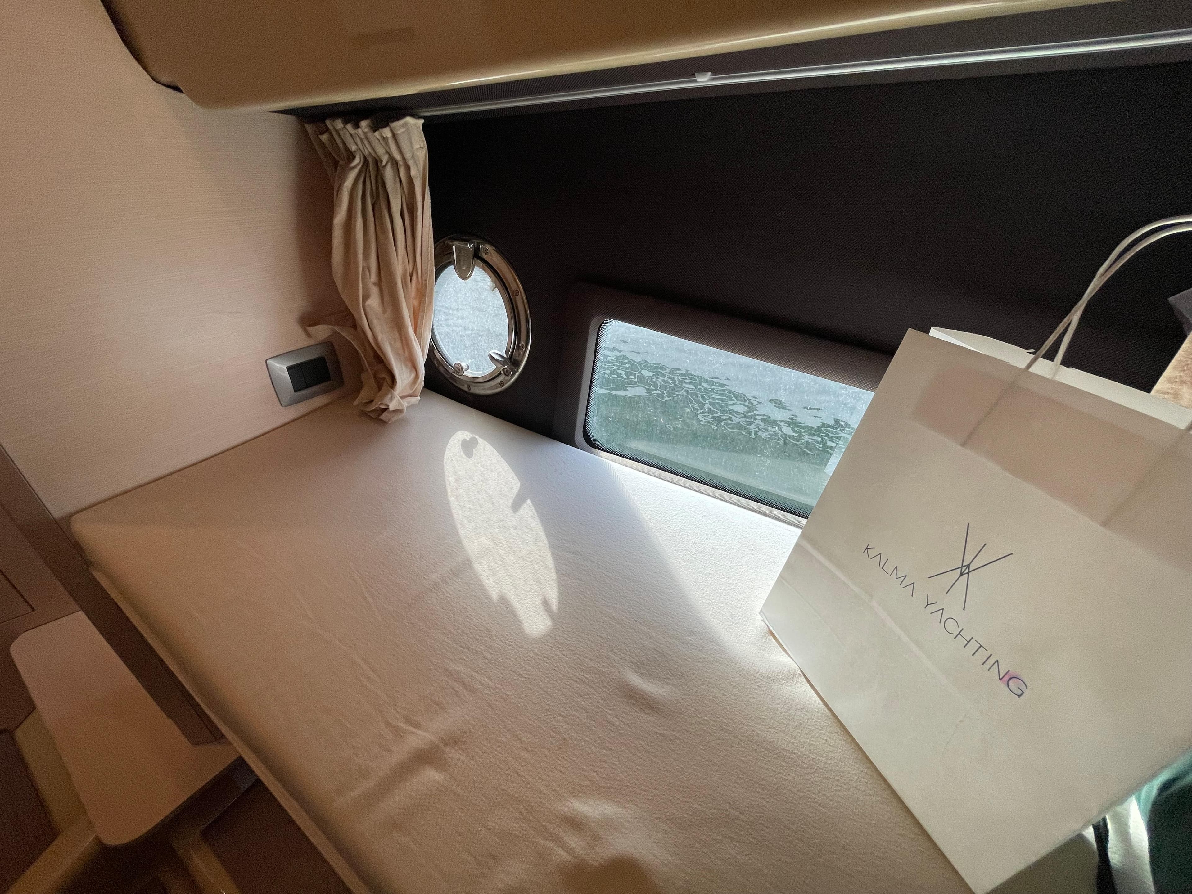 Interior cabin of 2012 Cranchi M38 yacht with window and shopping bag.