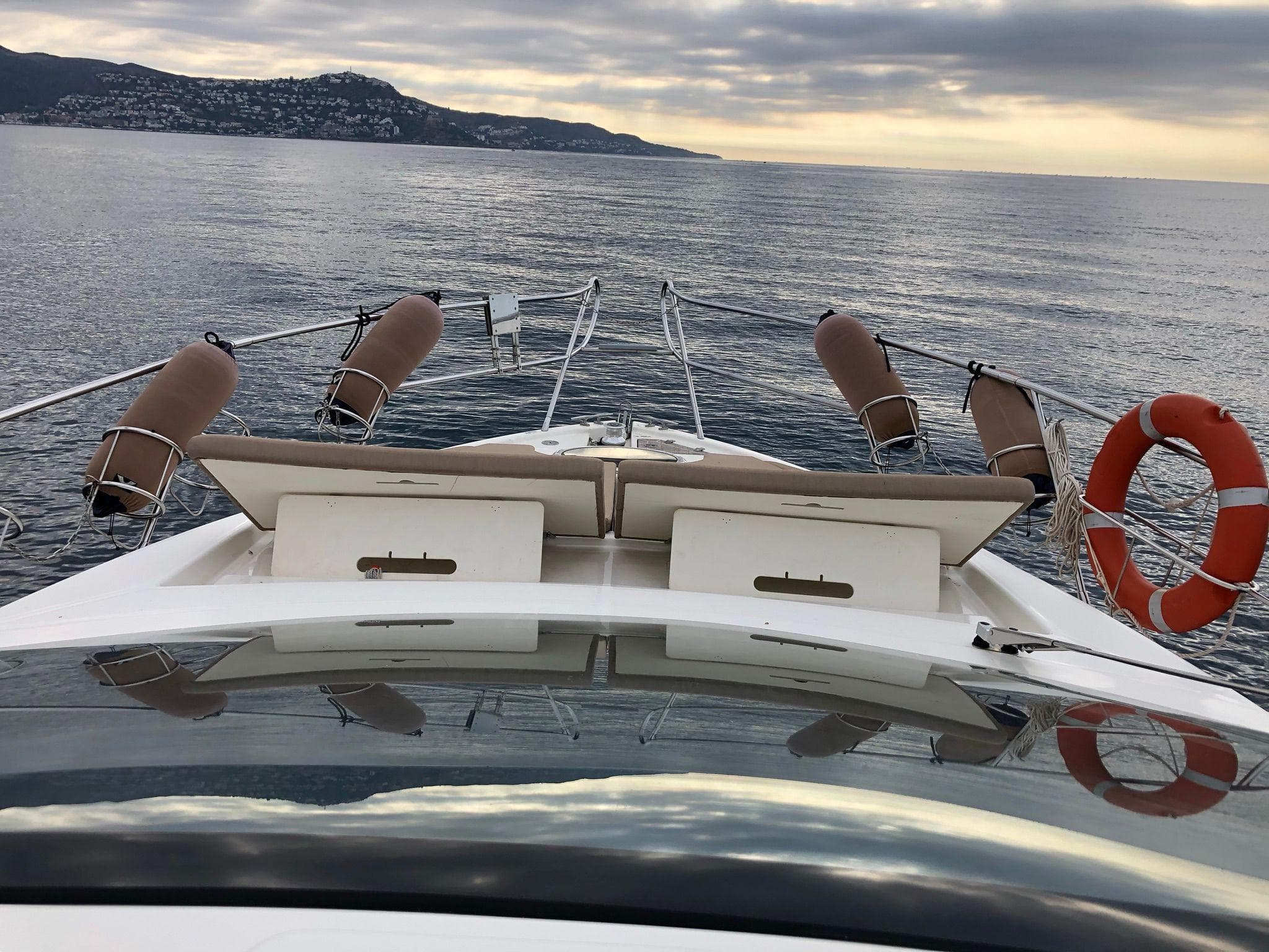 2012 Cranchi M38 yacht cruising on calm sea with scenic coastal backdrop.