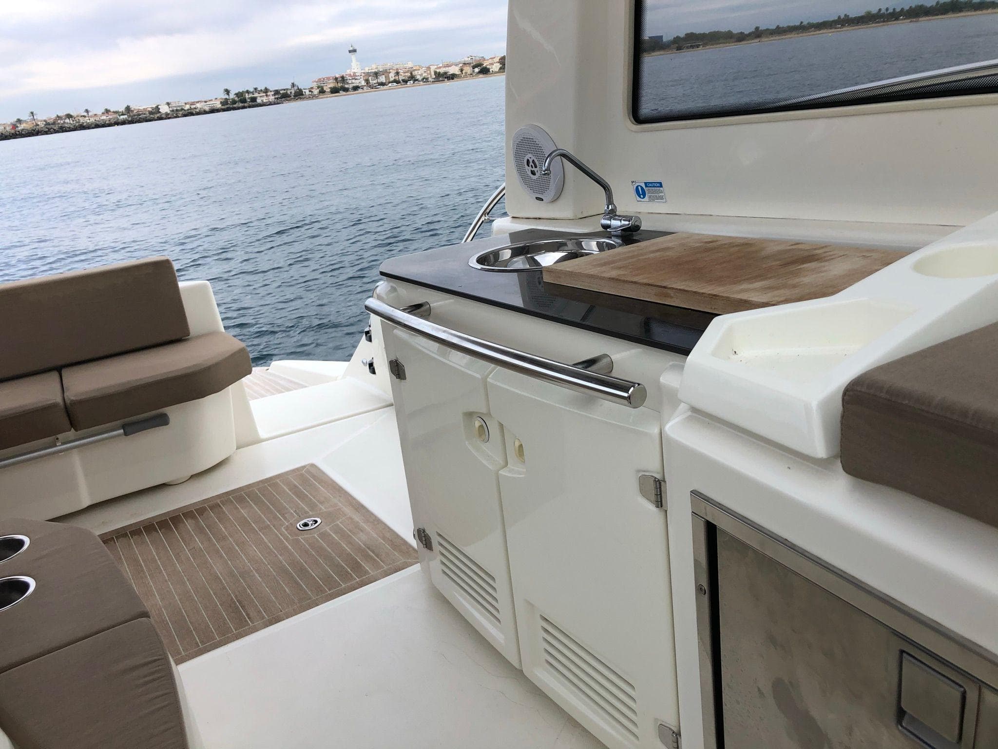 2012 Cranchi M38 yacht interior with kitchenette and seating, overlooking calm waters.