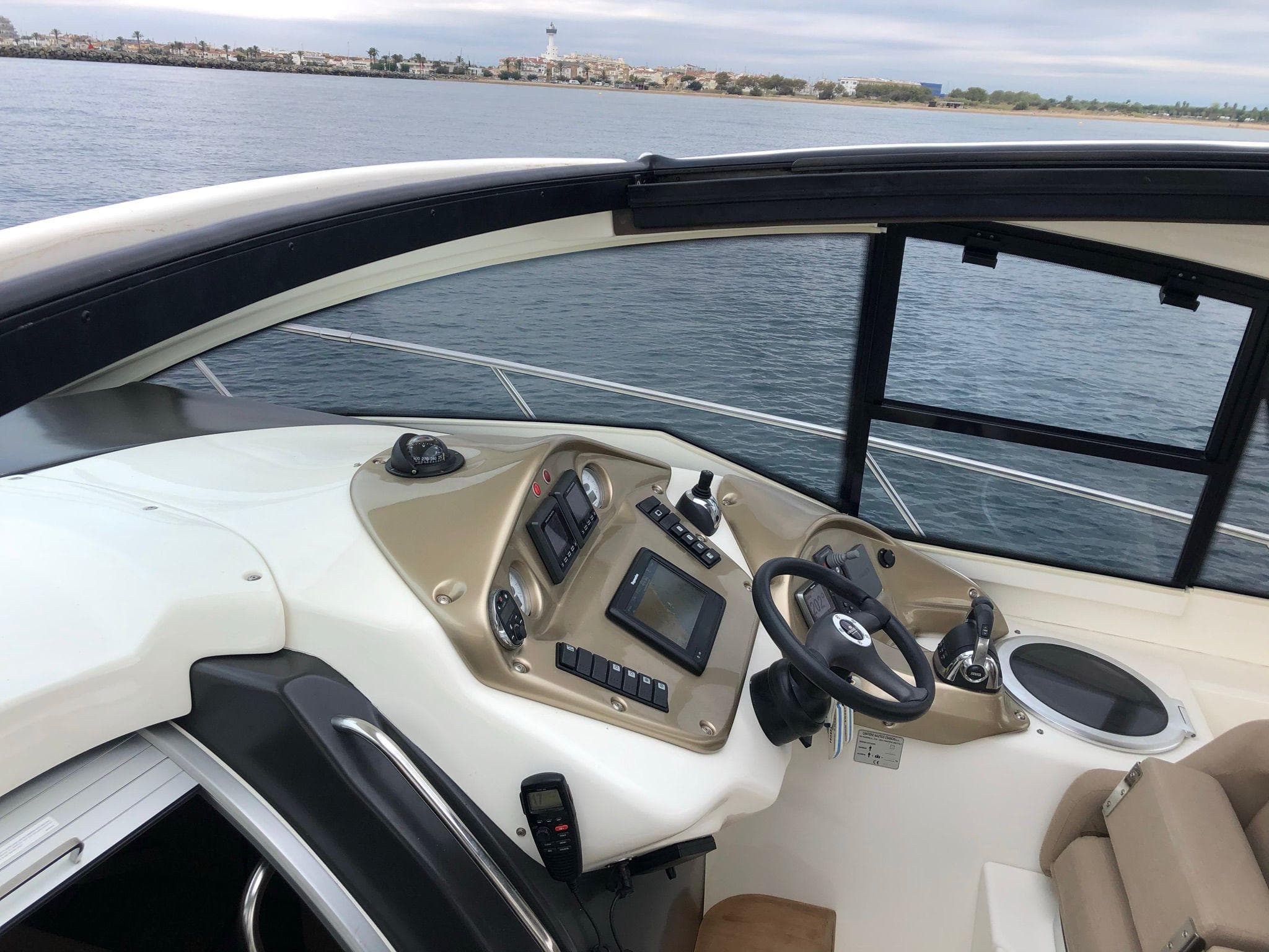 2012 Cranchi M38 yacht helm with modern controls, steering wheel, and ocean view.