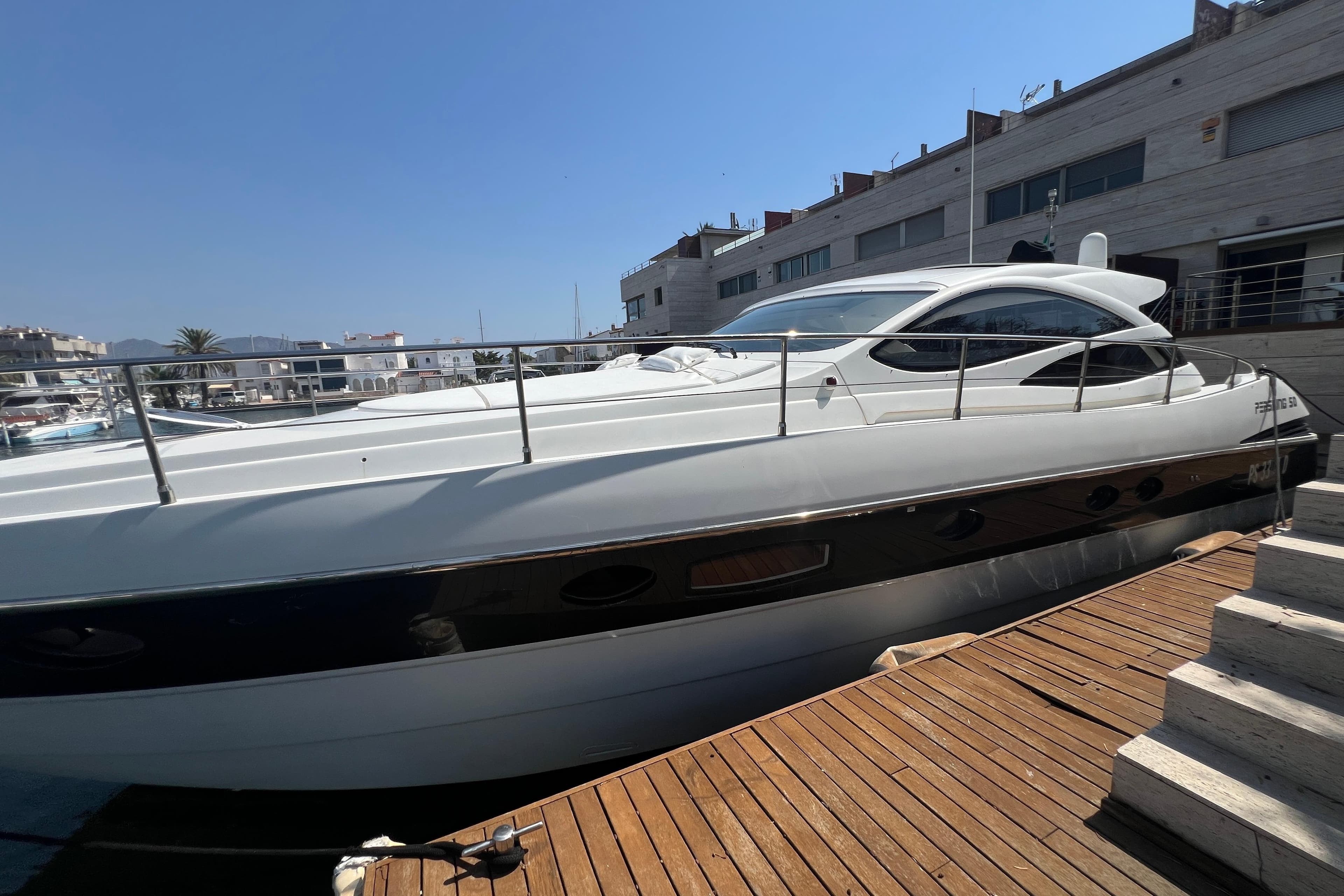 Luxury 2007 Pershing 50 yacht docked at marina under clear blue sky.