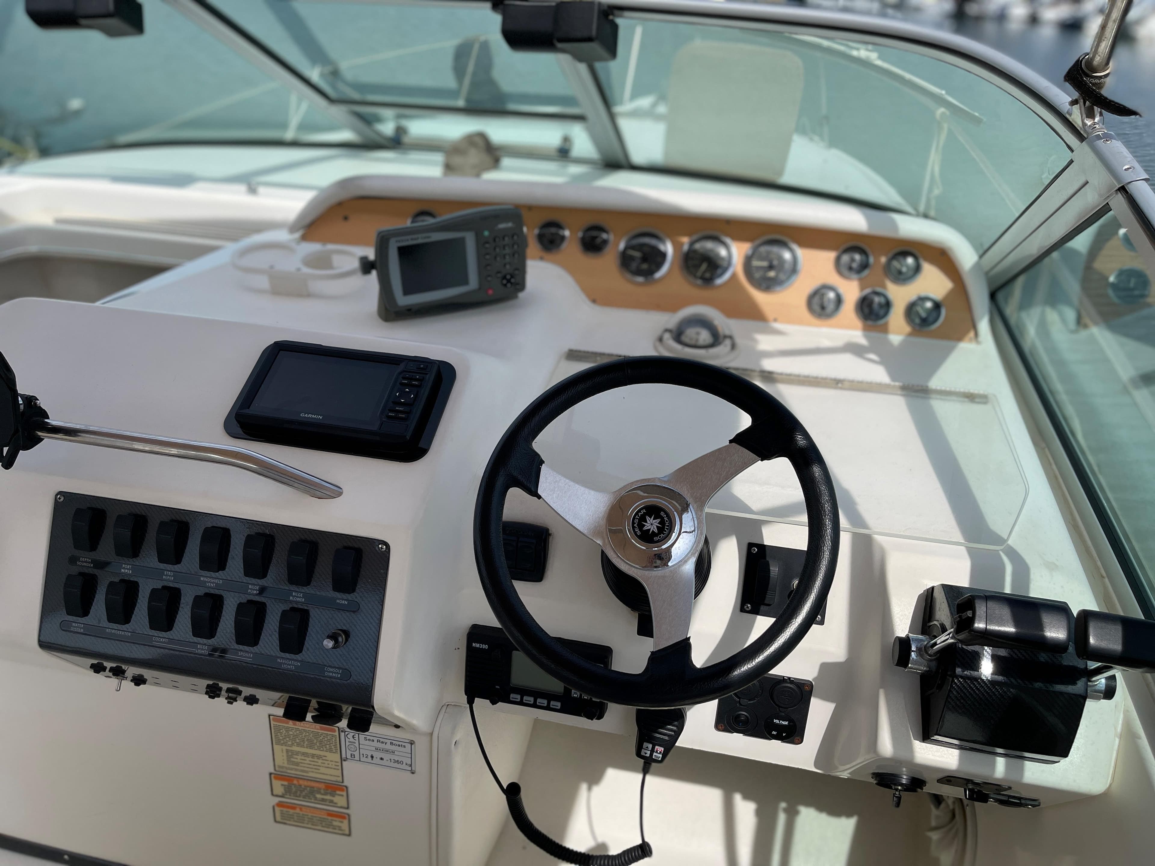 The image shows the helm of a 1997 Sea Ray 290 Sundancer with modern instruments.
