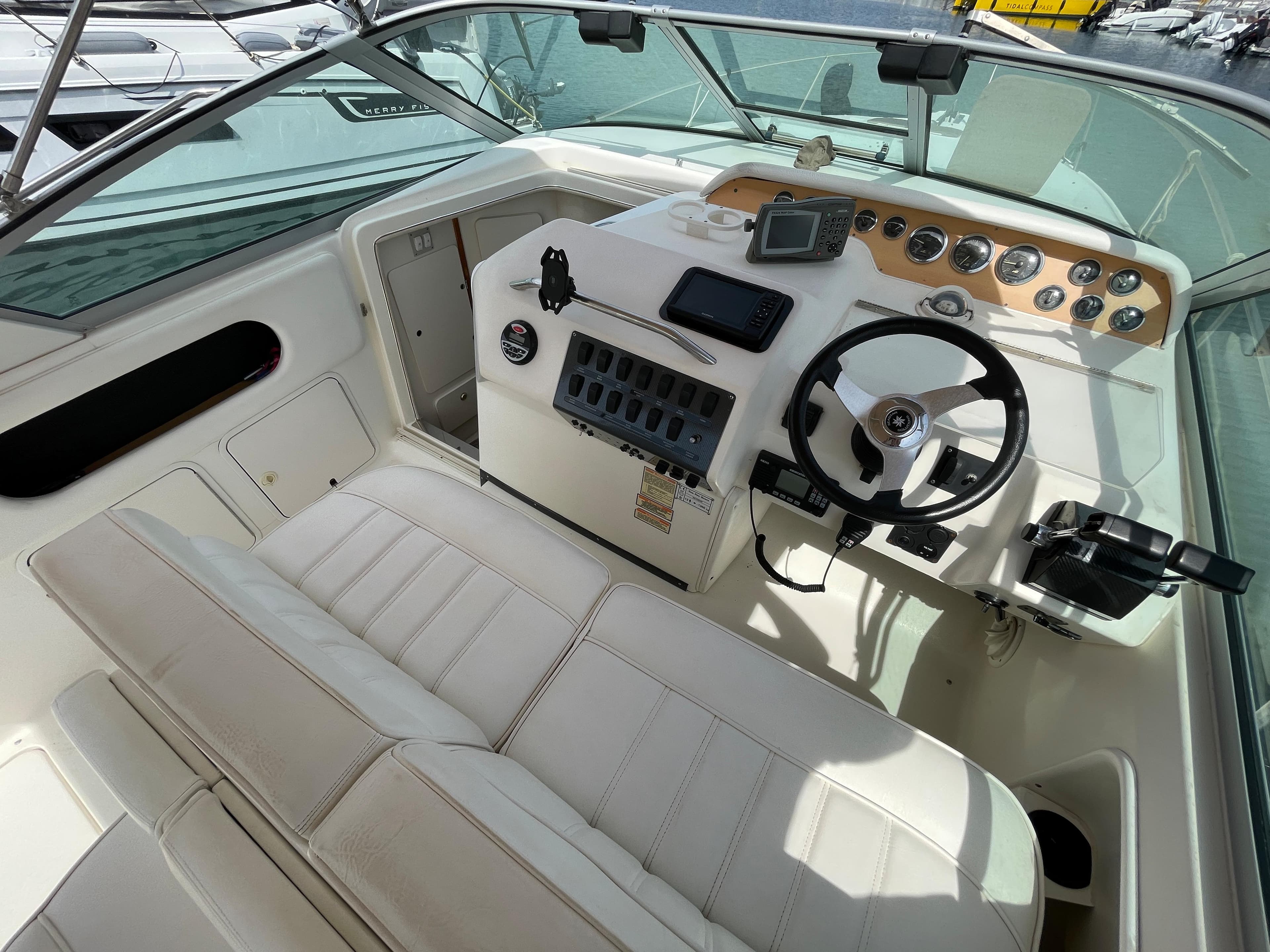 The image shows the cockpit of a 1997 Sea Ray 290 Sundancer with a white helm and instruments.