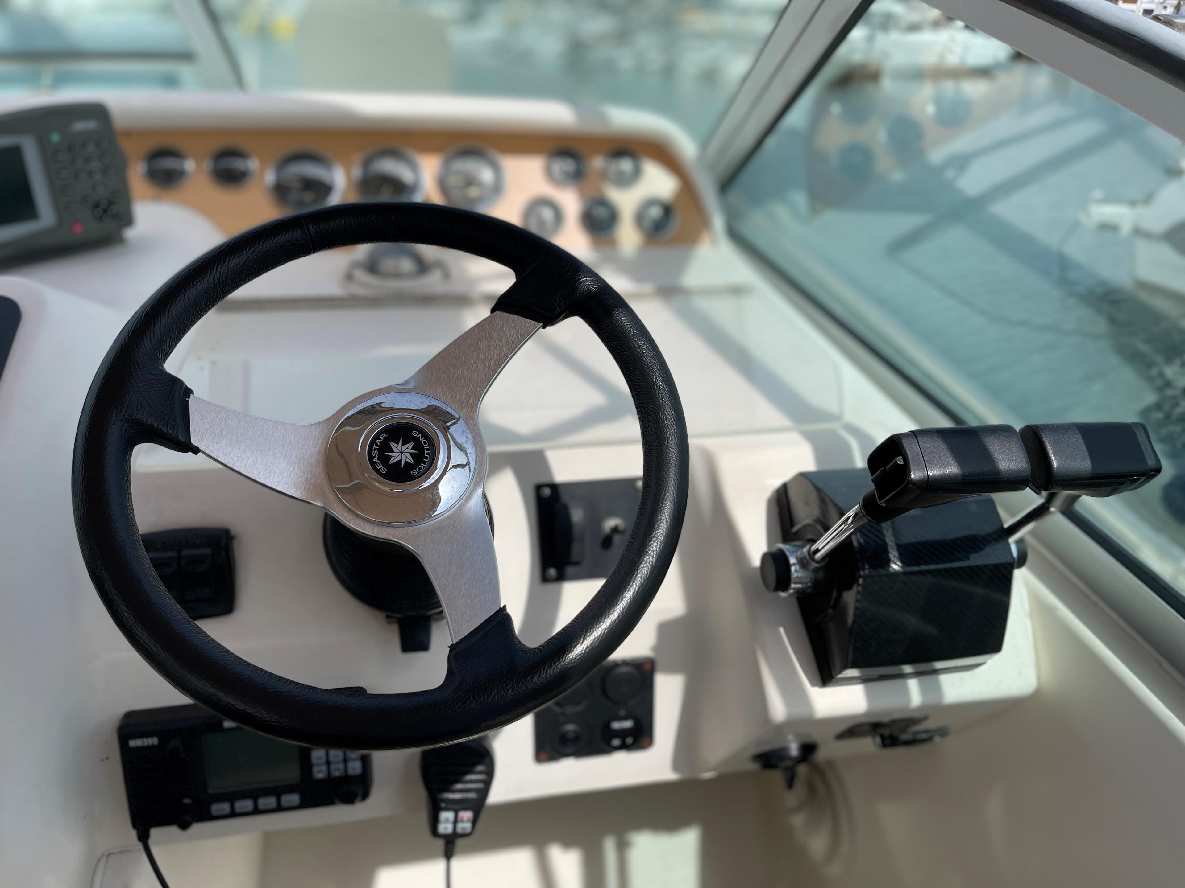 The image shows the helm of a 1997 Sea Ray 290 Sundancer with a steering wheel and instruments.