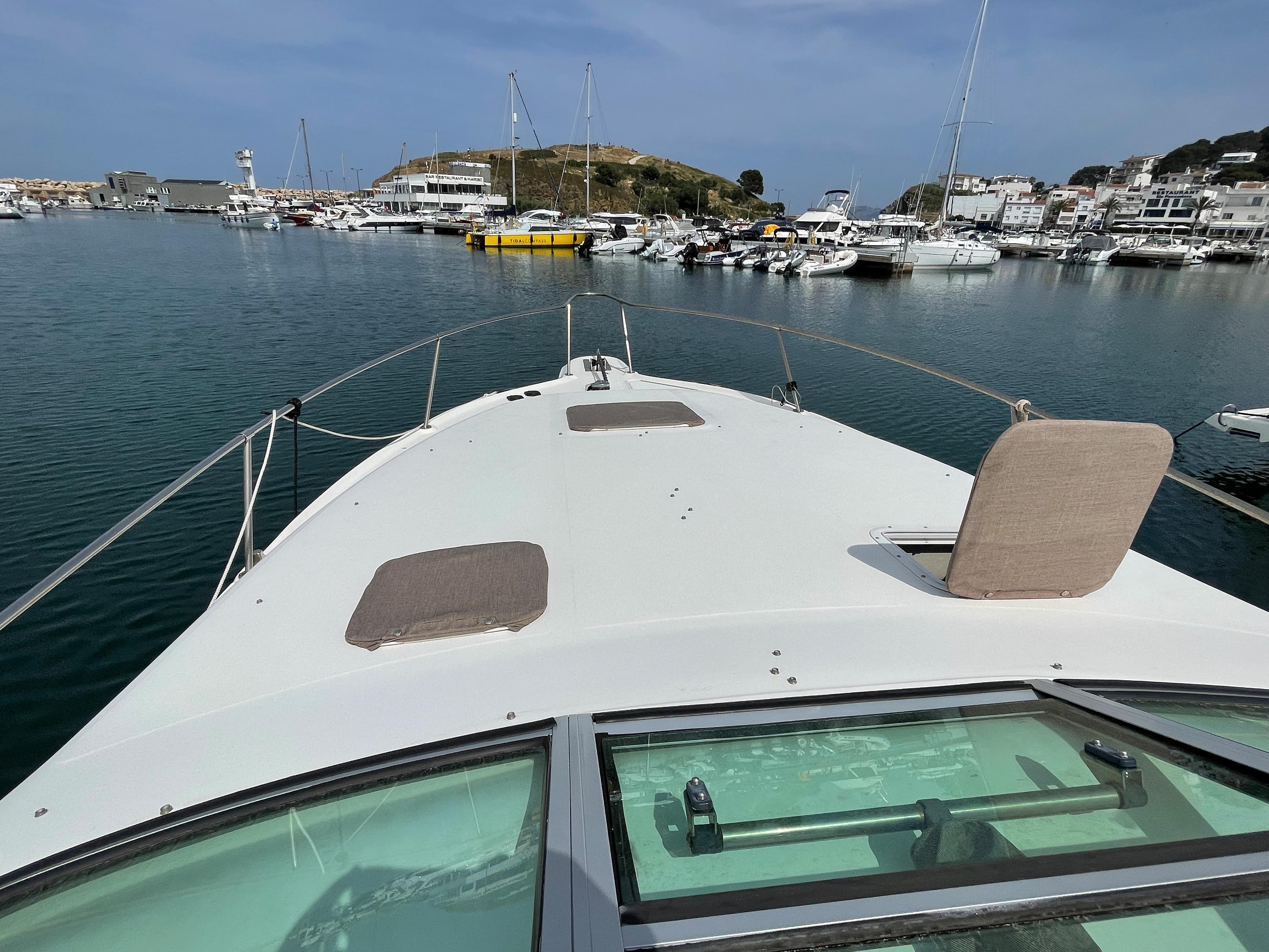 The image shows the foredeck of a 1997 Sea Ray 290 Sundancer in a marina.
