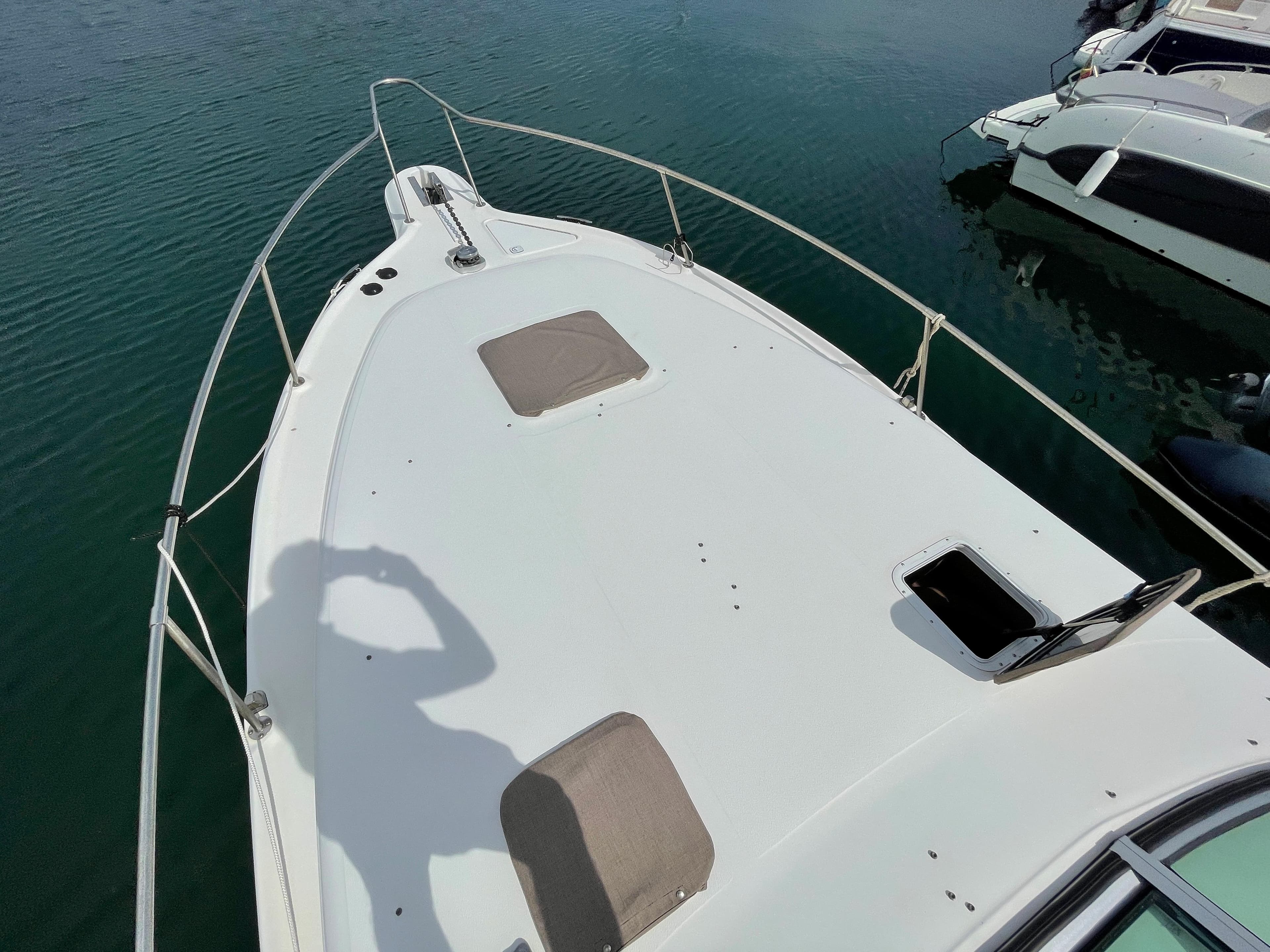 The image shows the foredeck of a 1997 Sea Ray 290 Sundancer on the water.