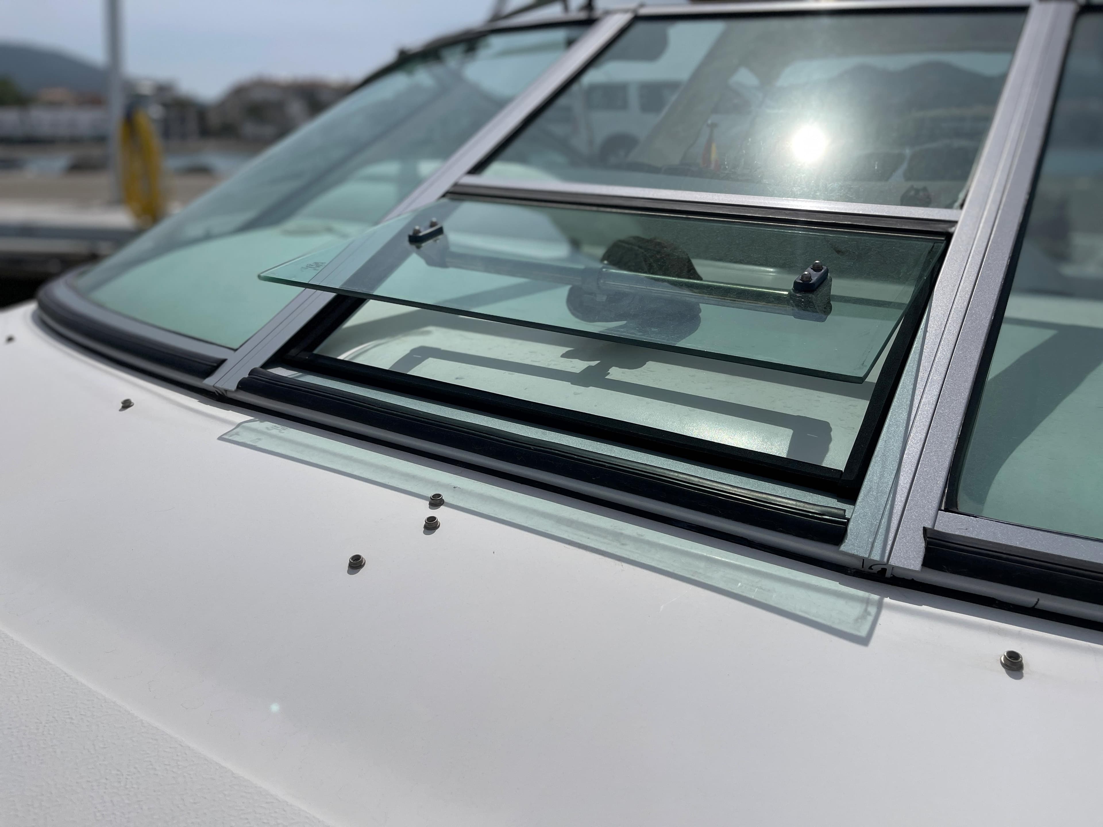Close-up of a 1997 Sea Ray 290 Sundancer window at a dock.