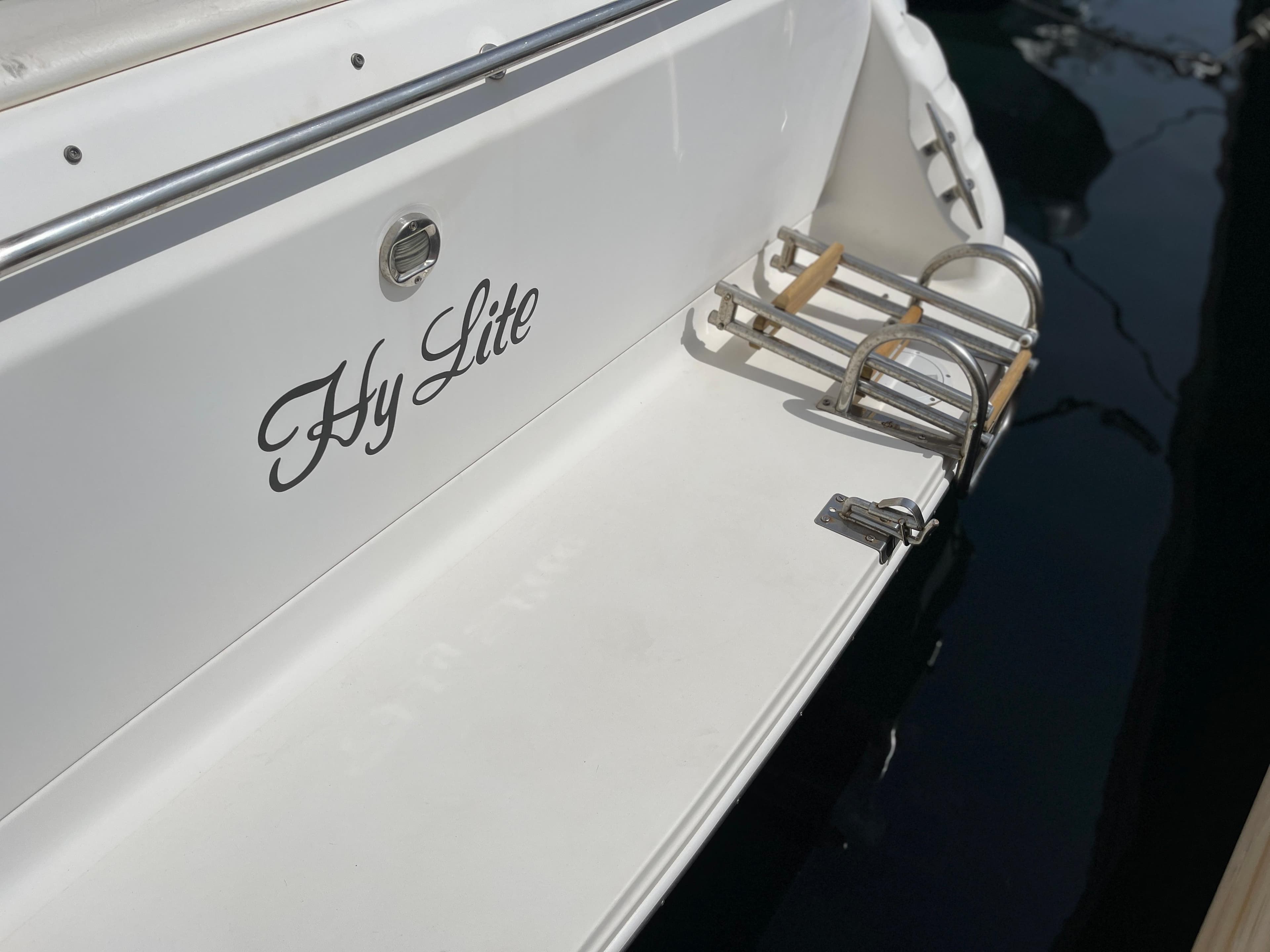 The image shows the stern of a boat named "Hy Lite" with a swim ladder.
