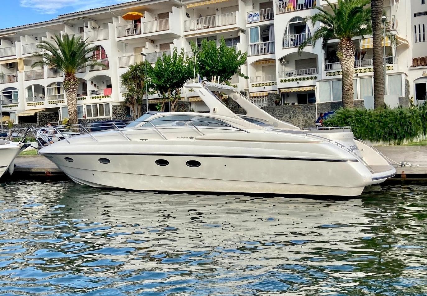 Luxury yacht Windy Bora 40 from 2003 docked near modern buildings.