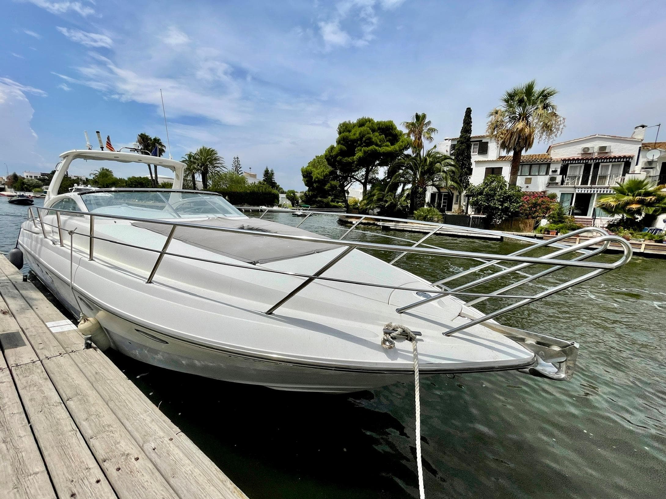 2003 Windy Bora 40 yacht docked, surrounded by water and palm trees.