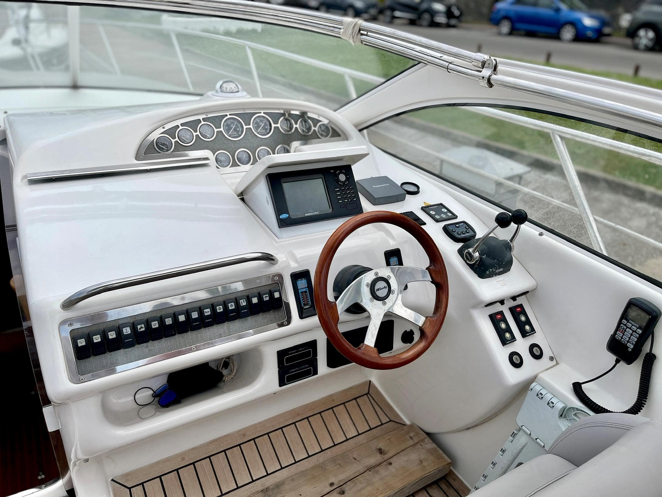Windy Bora 40 yacht helm, 2003 model, featuring wooden steering wheel and dashboard.