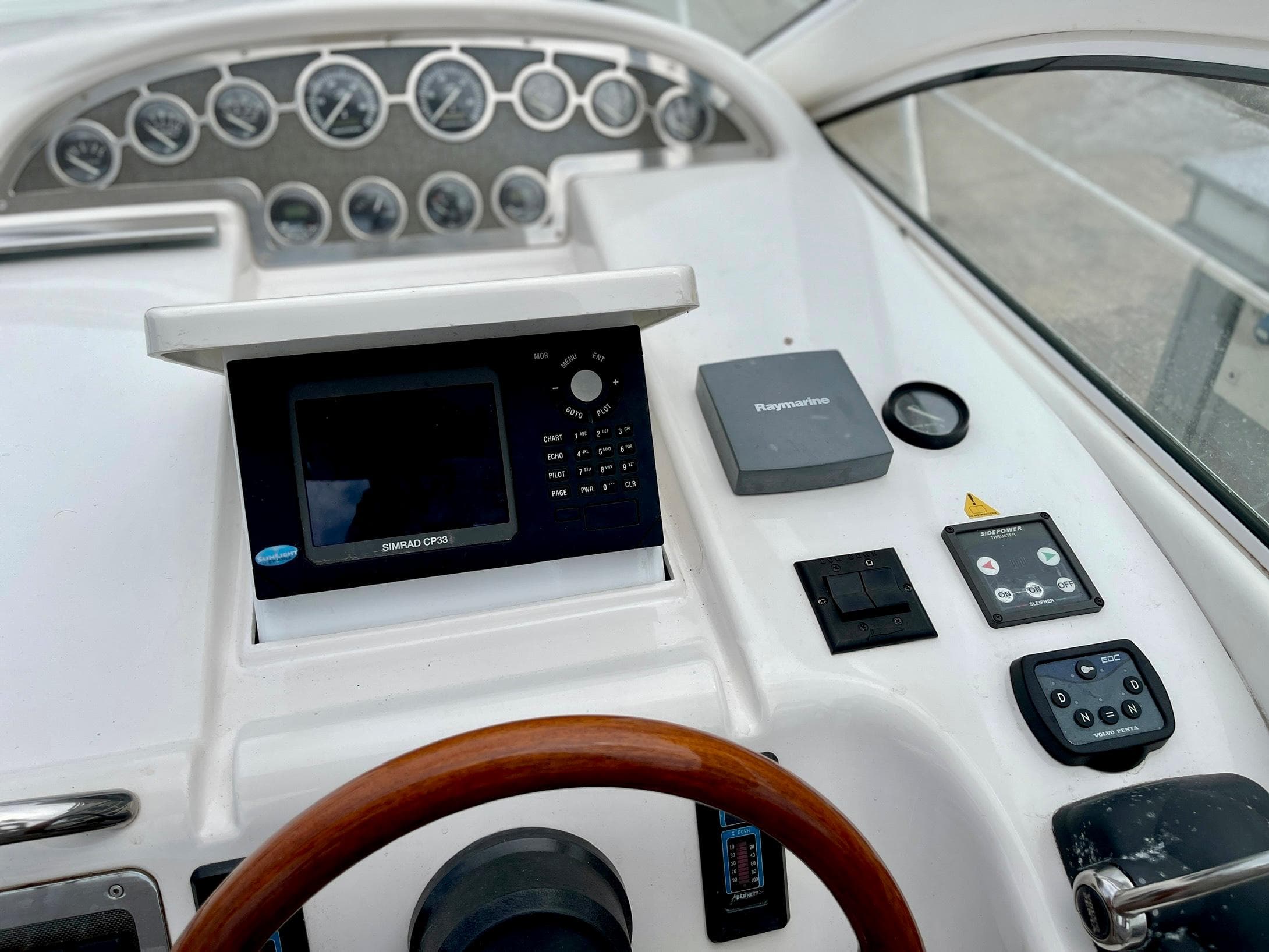 Windy Bora 40 yacht helm, 2003 model, featuring instruments and wooden steering wheel.