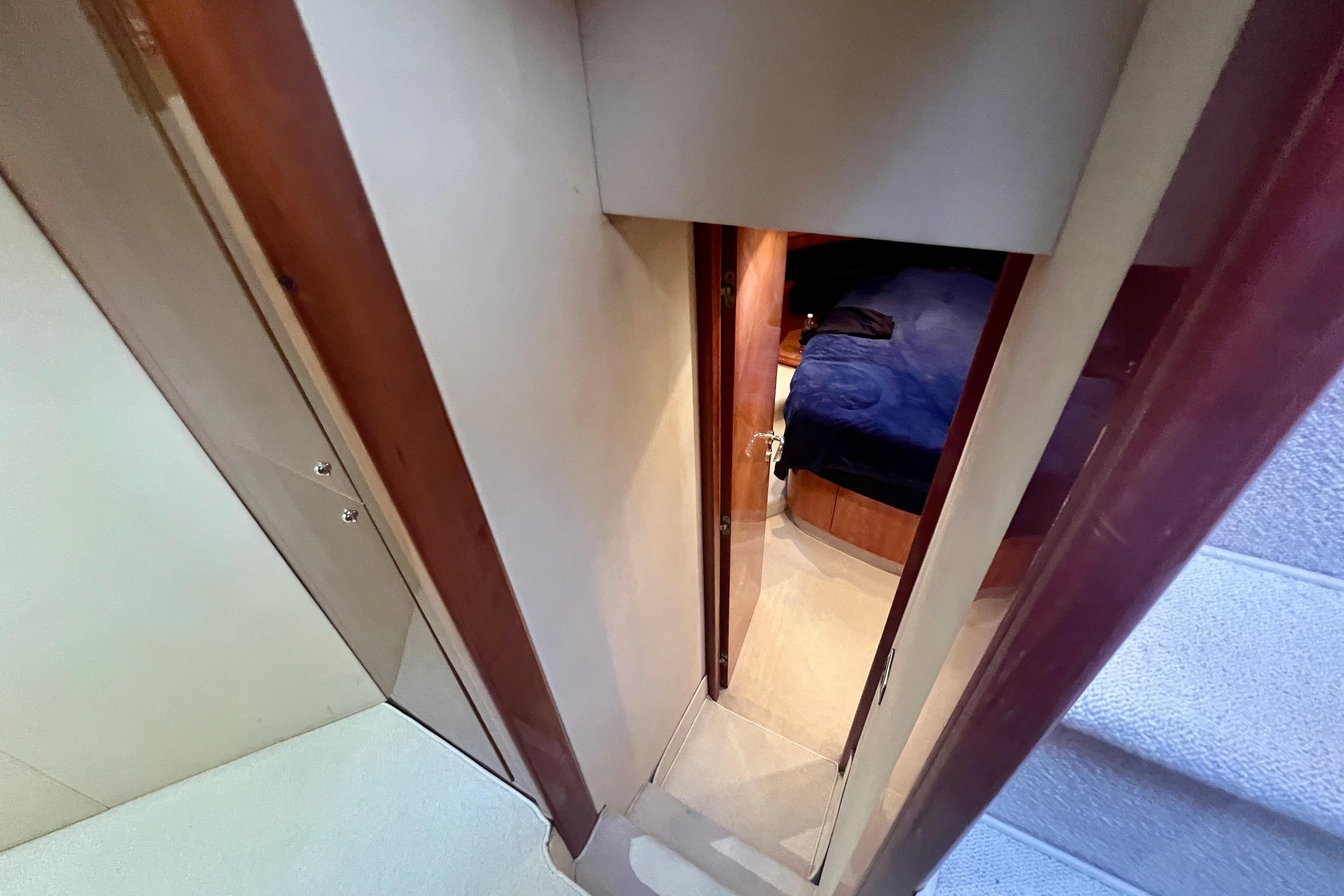 Interior view of 2002 Aicon 56 yacht, showing a narrow hallway leading to a bedroom.