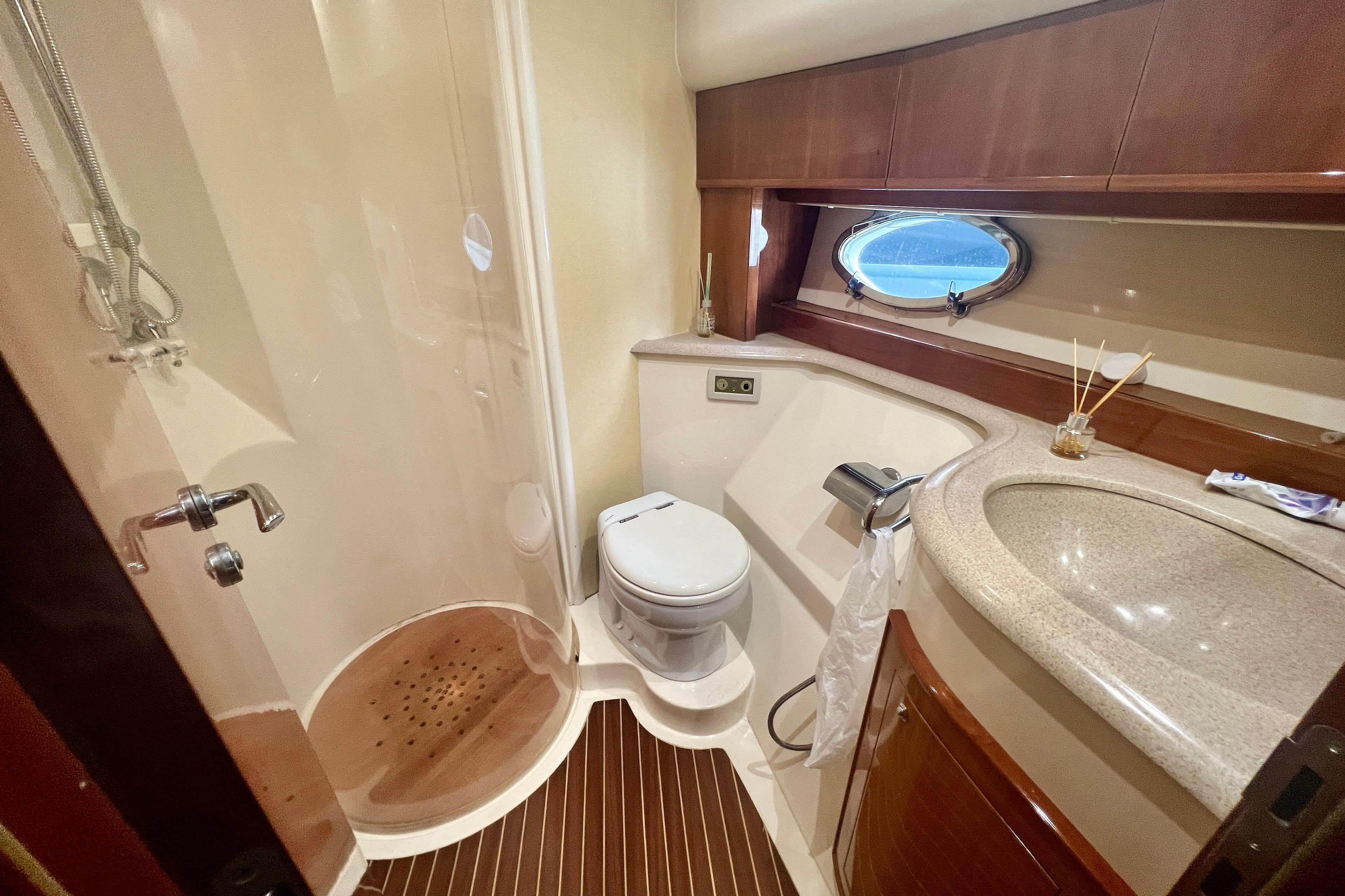 Luxurious bathroom in 2002 Aicon 56 yacht with shower, toilet, and sink.