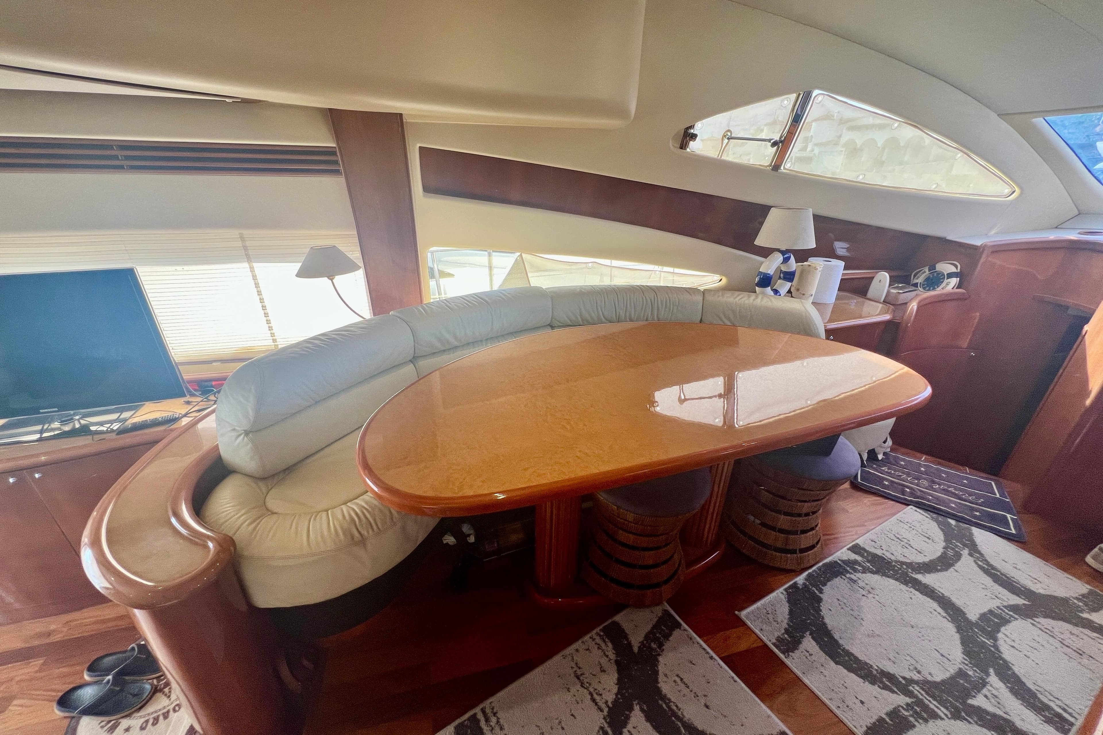 Luxurious interior of 2002 Aicon 56 yacht with elegant seating and wooden table.
