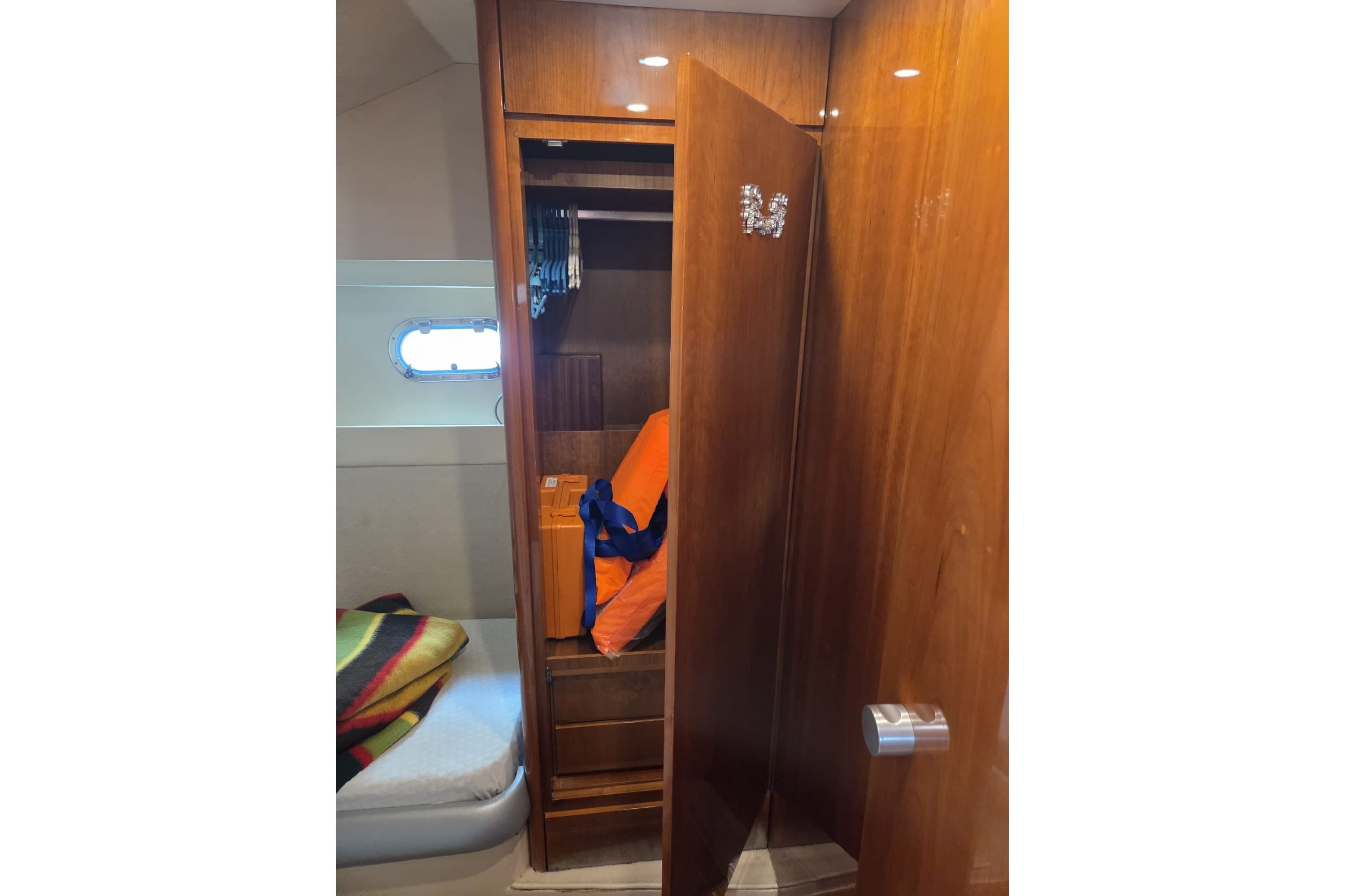 Wooden closet interior on 1994 Azimut 43 yacht, with bedding and storage.