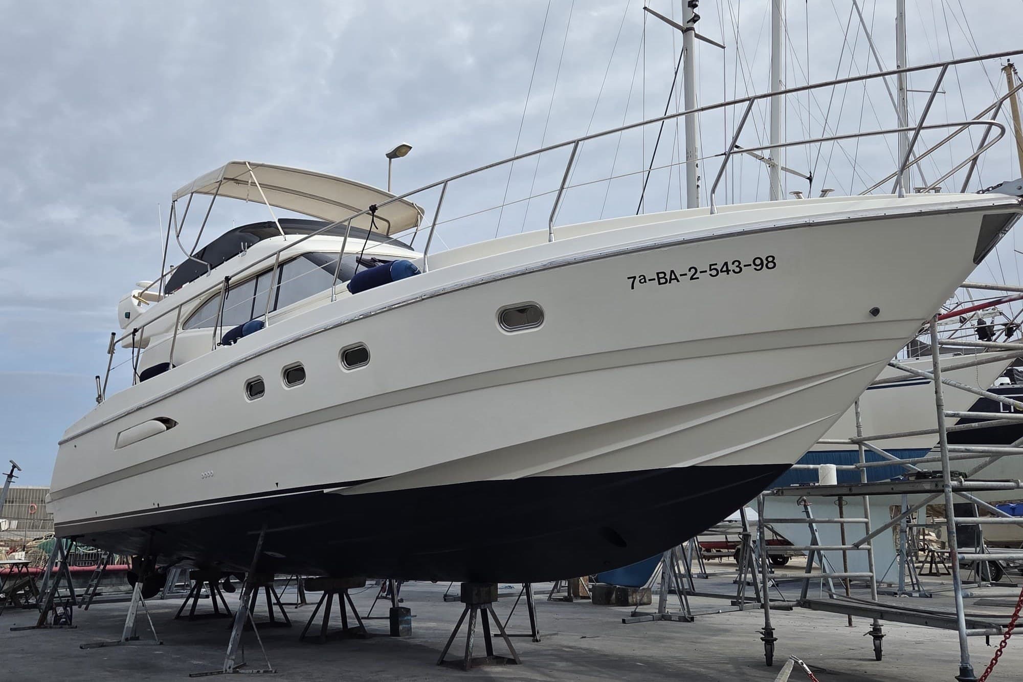 Azimut 43 yacht from 1994 on dry dock, showcasing sleek design and structure.