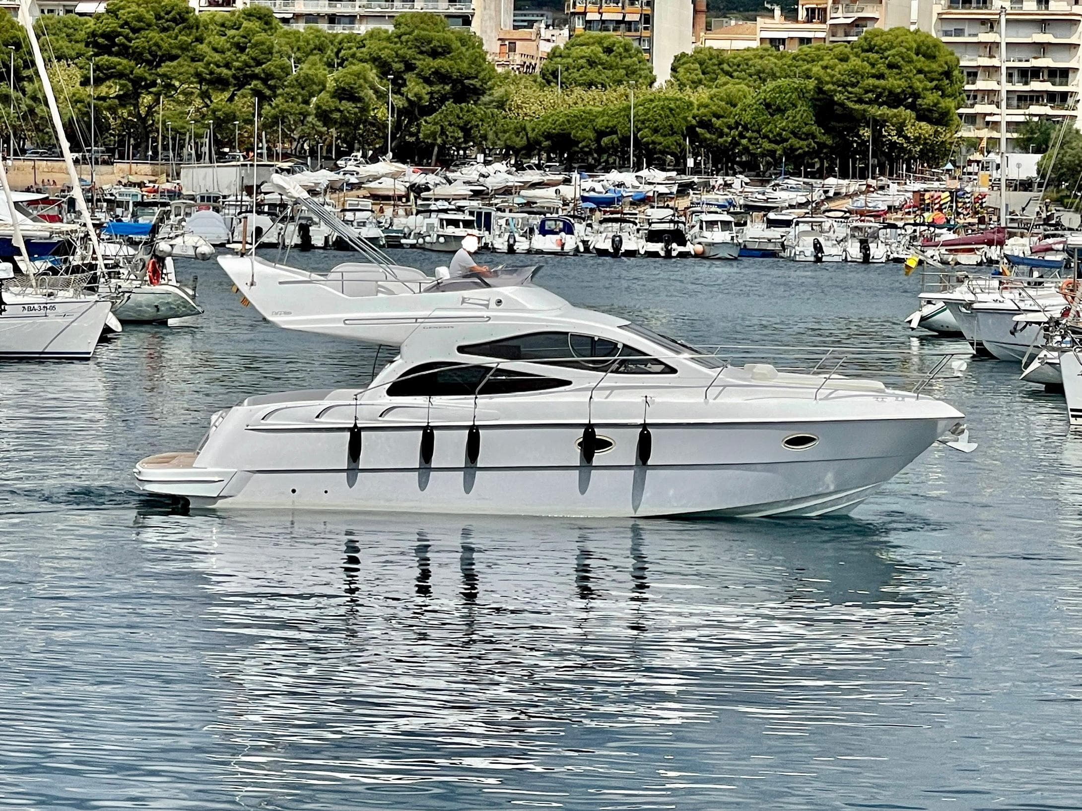 2006 Genesis Boats 37 Flybridge yacht docked in a marina, surrounded by other boats.