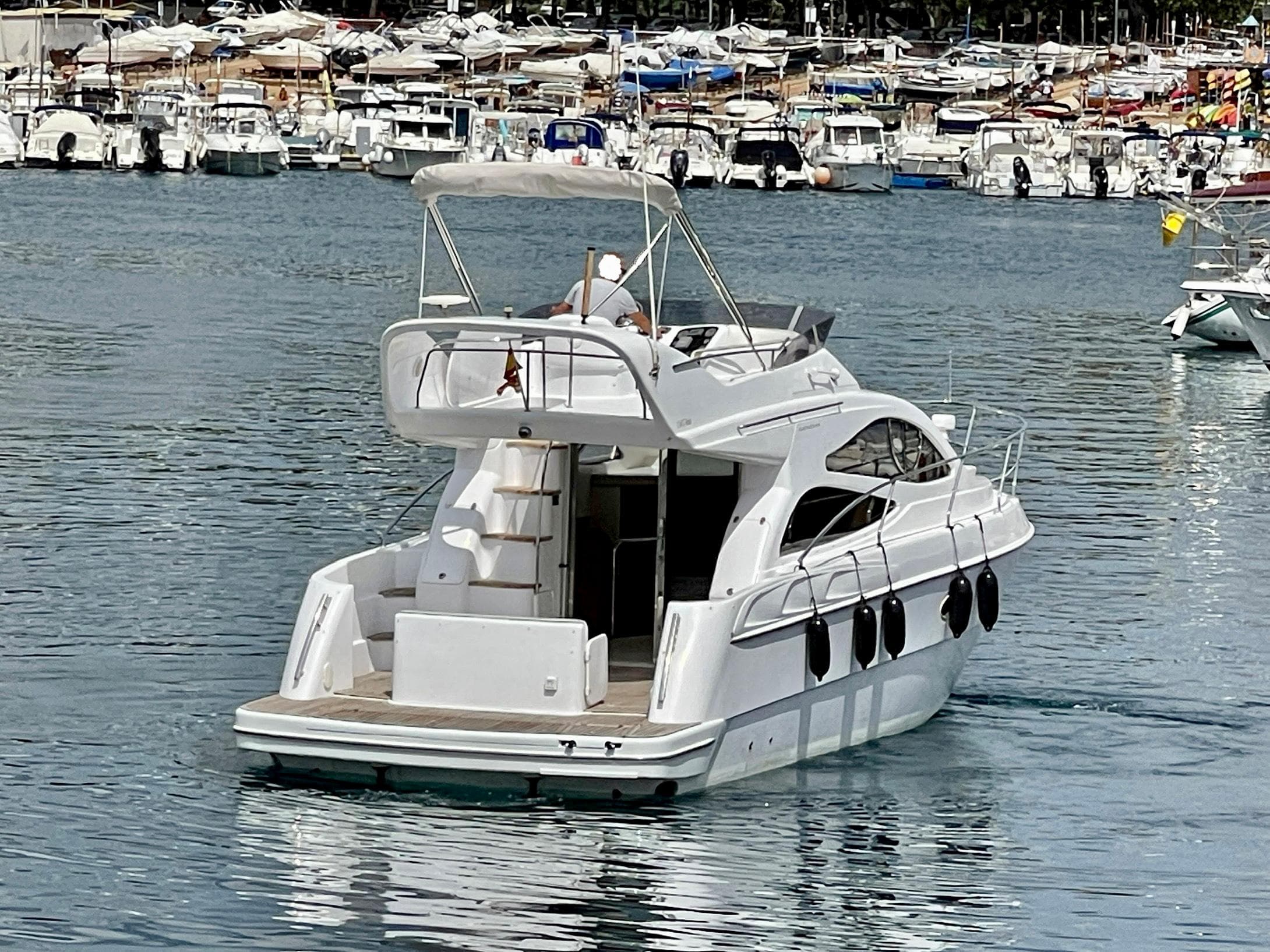 2006 Genesis Boats 37 Flybridge yacht cruising in a busy marina.