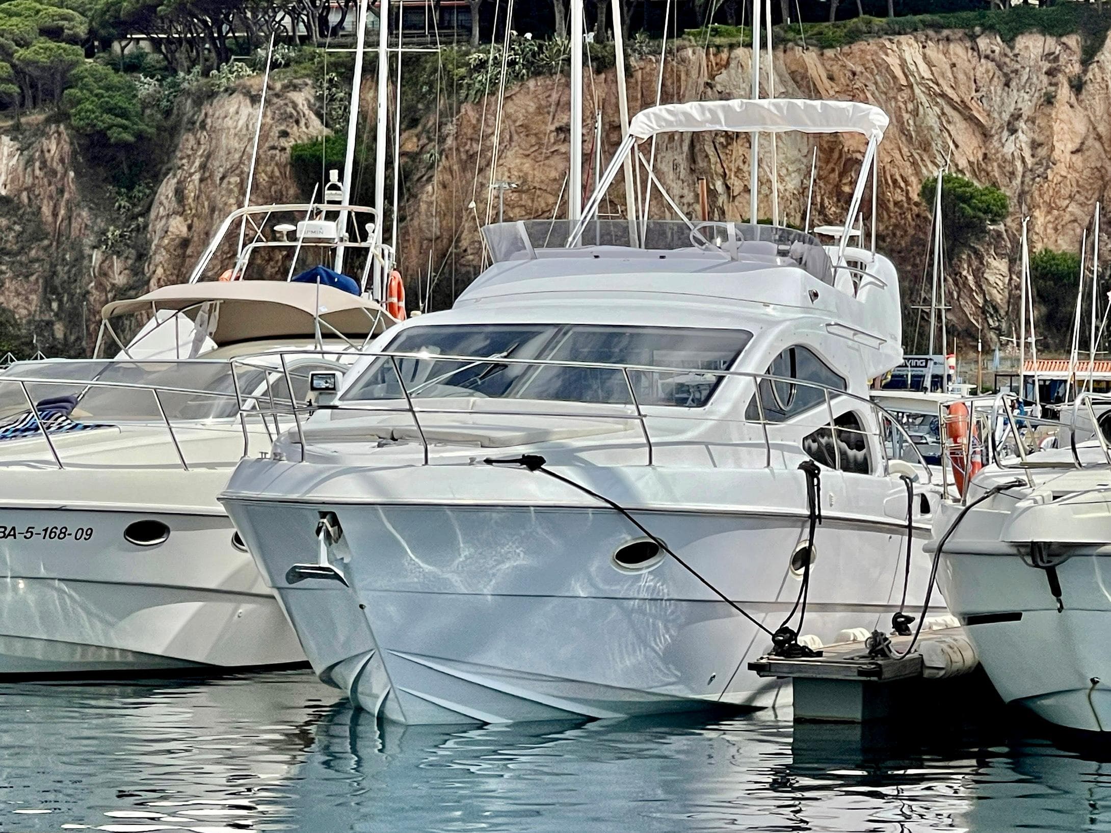 Genesis Boats 37 Flybridge 2006 yacht docked in a marina, surrounded by other boats.