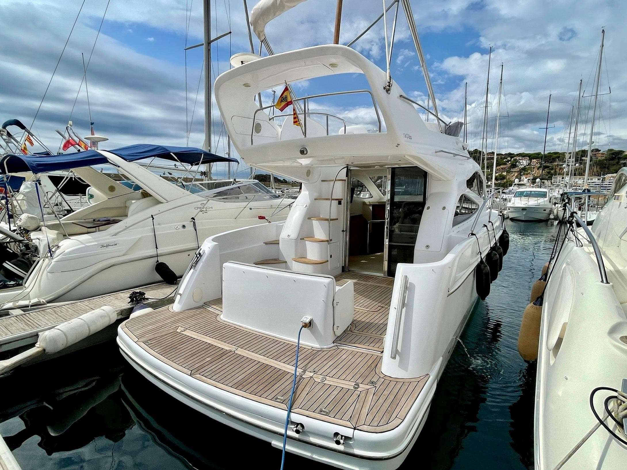 2006 Genesis Boats 37 Flybridge yacht docked at marina, showcasing elegant design and spacious deck.