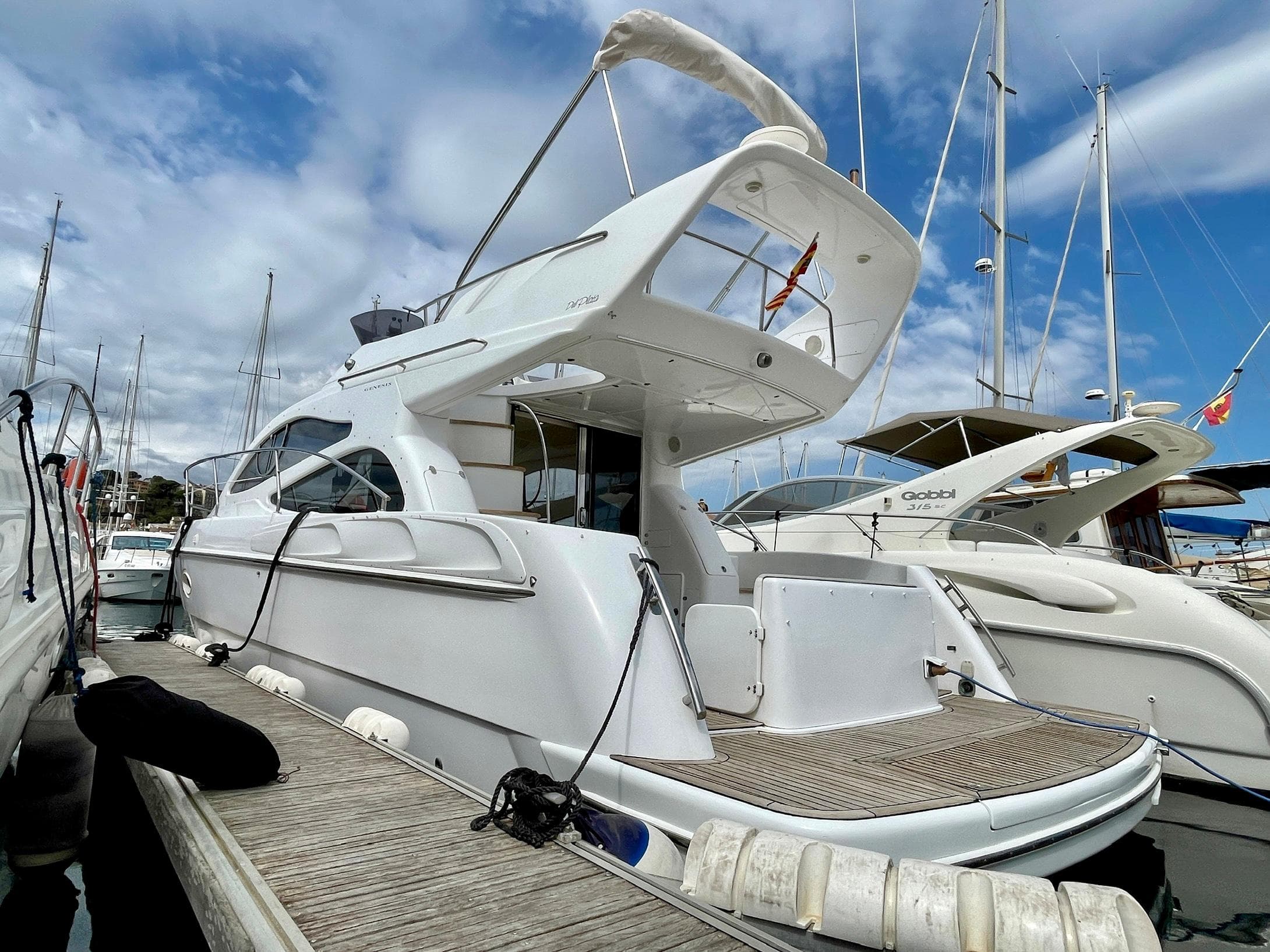 2006 Genesis Boats 37 Flybridge docked, showcasing sleek design and spacious flybridge.