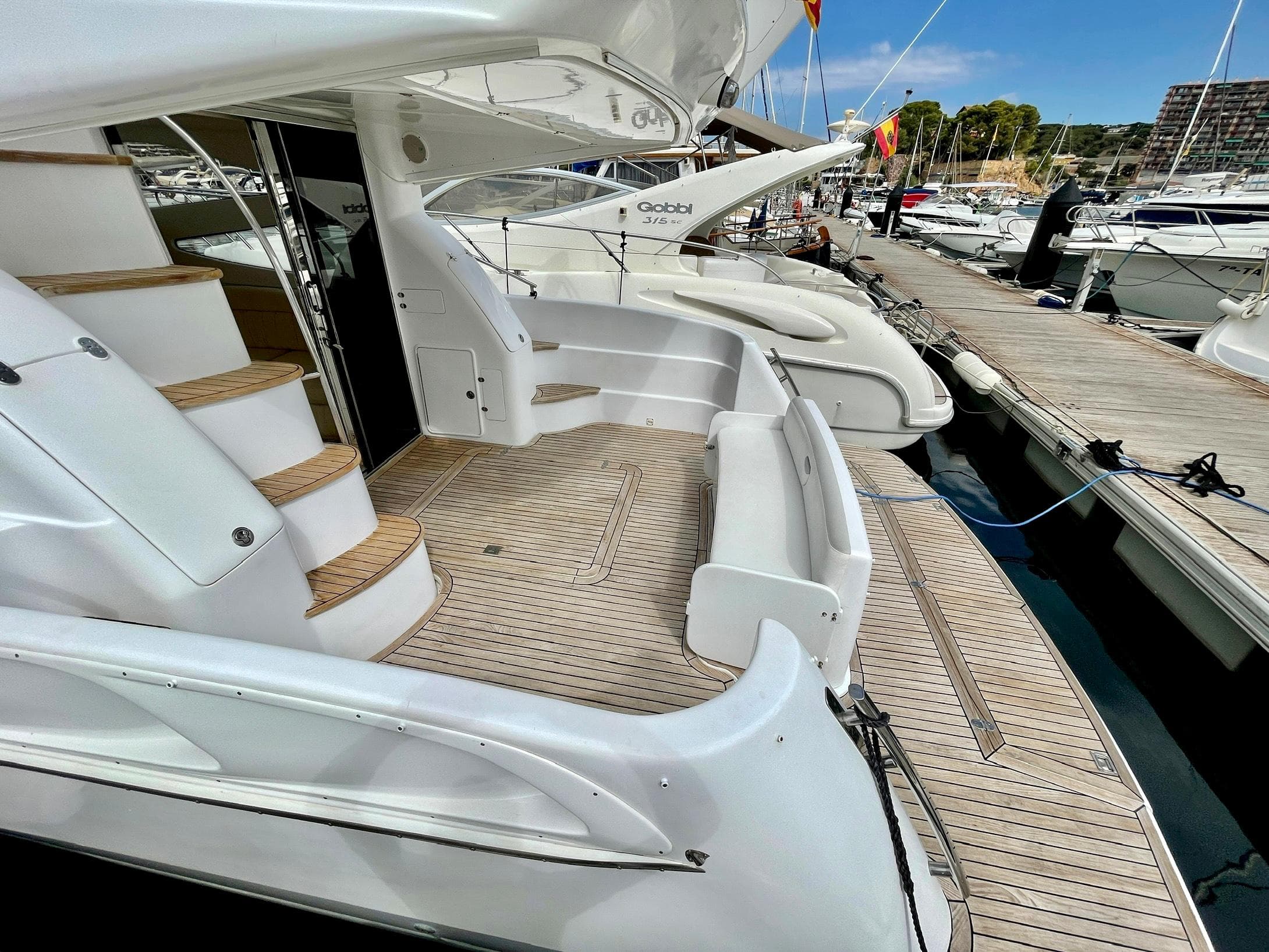 2006 Genesis Boats 37 Flybridge yacht docked, featuring elegant white design and spacious deck.