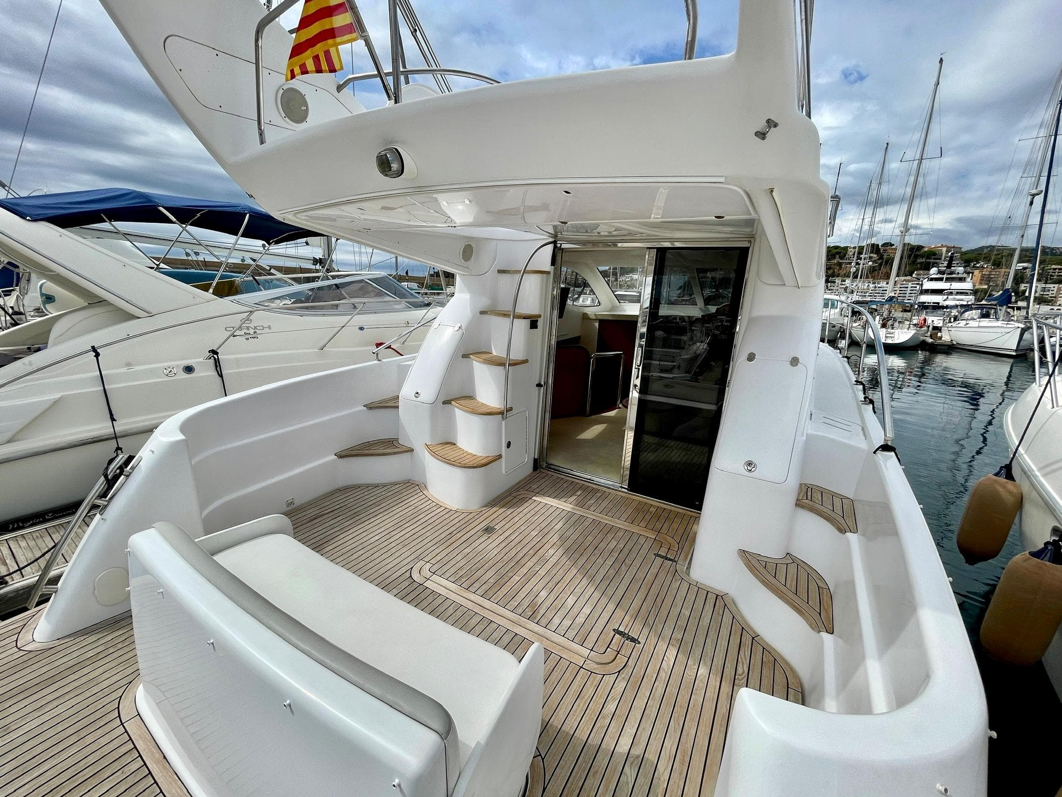 Genesis Boats 37 Flybridge 2006, spacious deck with stairs, docked at marina.