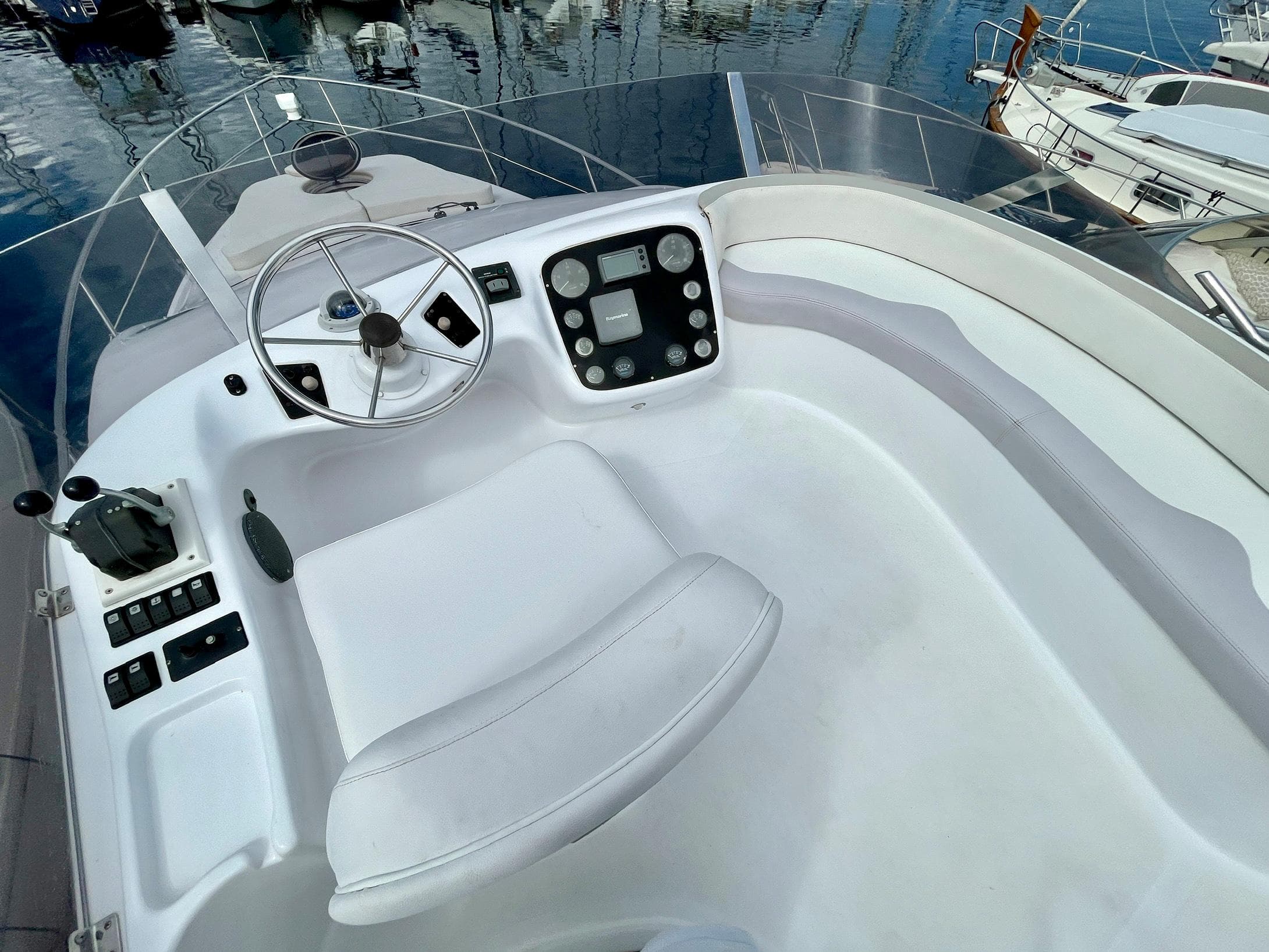 Flybridge helm of 2006 Genesis Boats 37, featuring steering wheel and control panel.