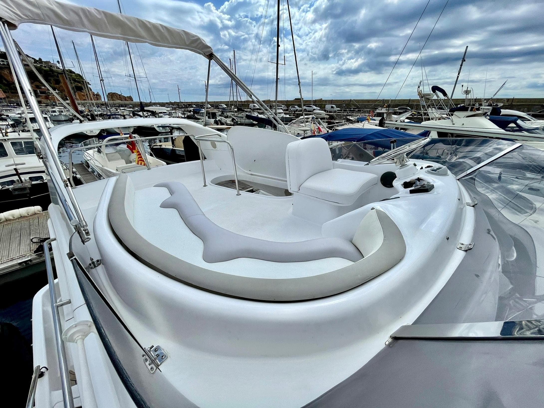 2006 Genesis Boats 37 Flybridge with sleek design, docked in a marina under cloudy skies.