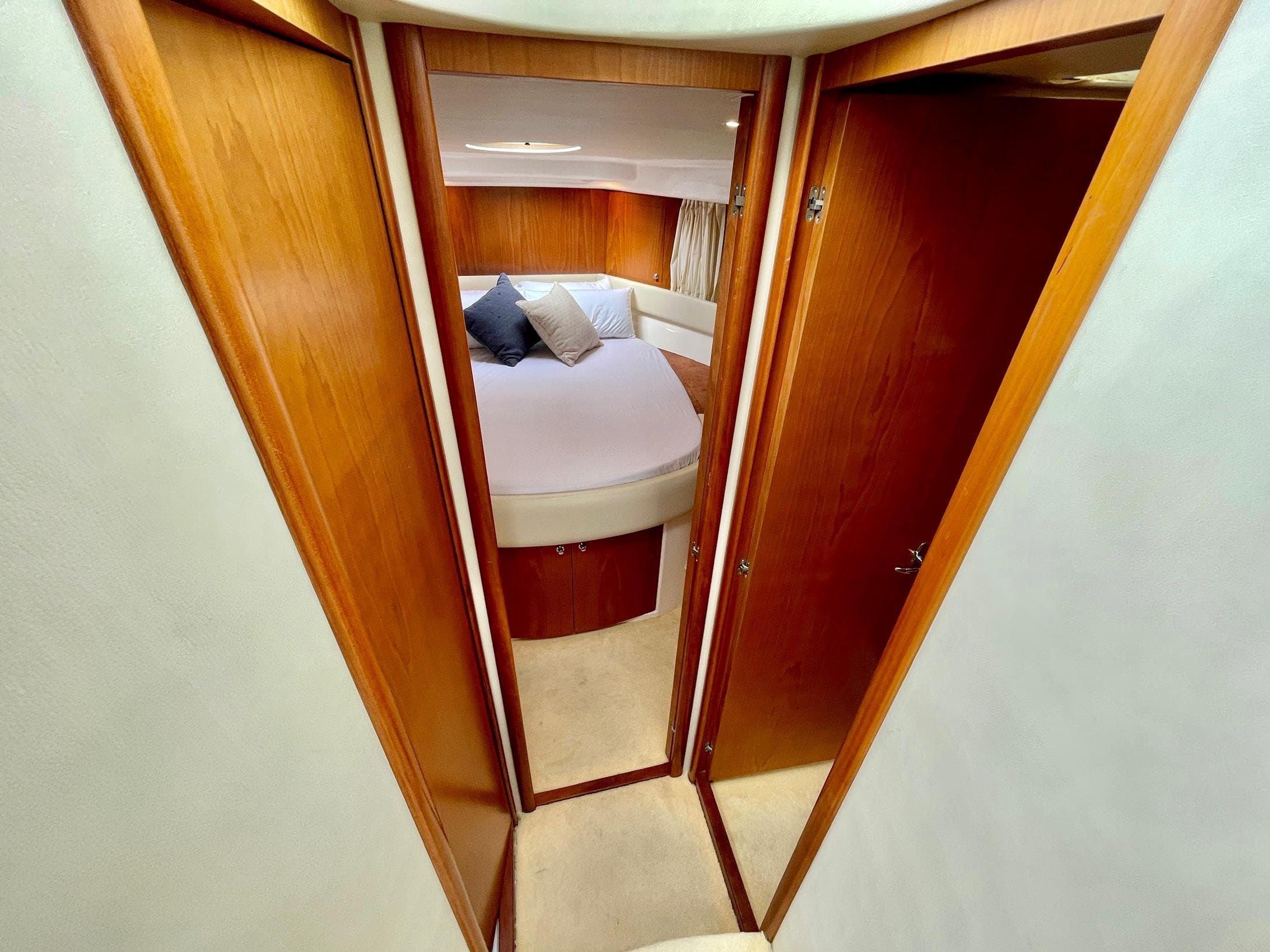 Interior view of 2006 Genesis Boats 37 Flybridge cabin with wood paneling and cozy bed.