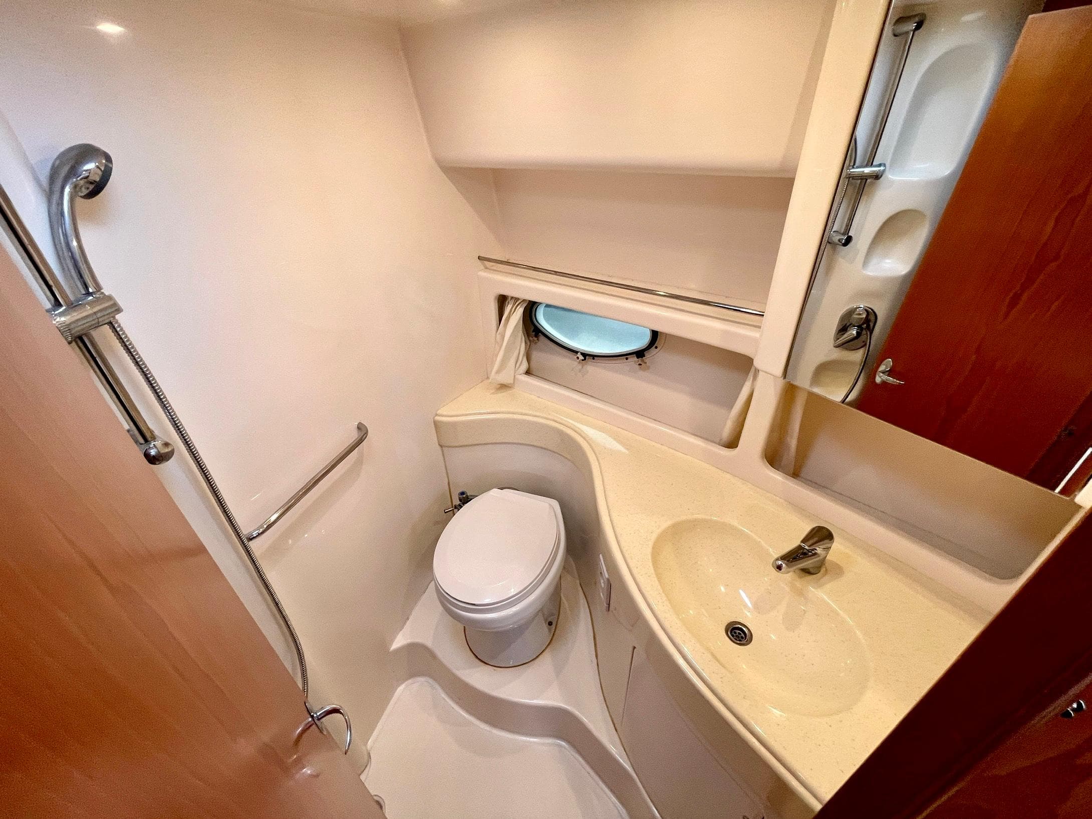 2006 Genesis Boats 37 Flybridge bathroom with shower, sink, and porthole window.