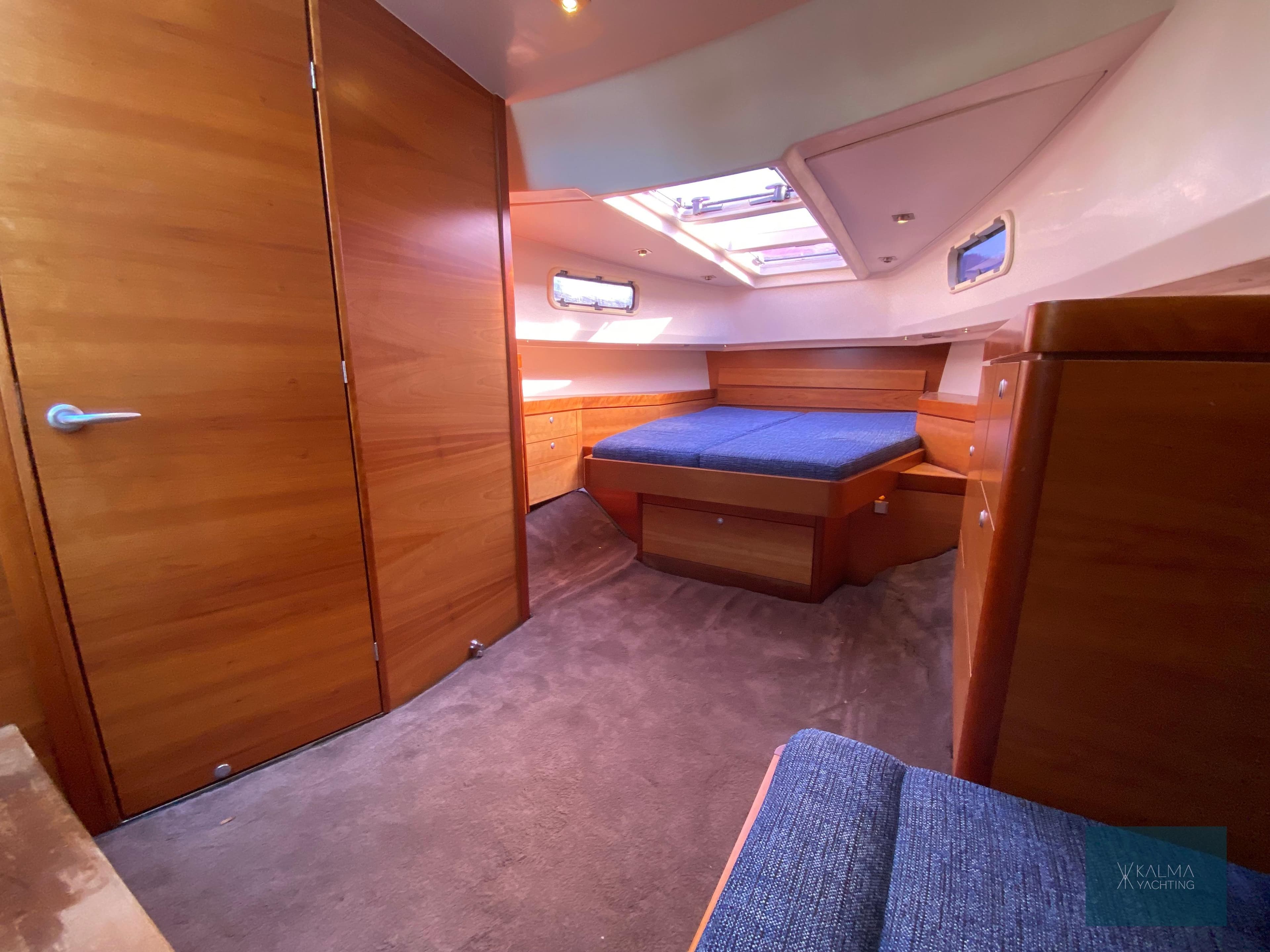 Interior of 2008 Fjord 40 Open yacht with wooden furnishings and blue upholstery.