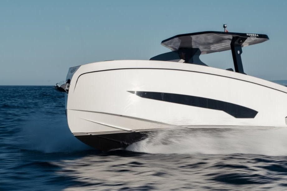Futuristic 2026 Kumbra 36 boat cruising swiftly on open water.