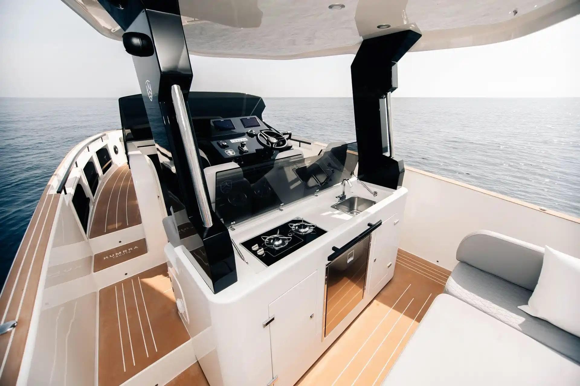 Luxurious 2026 Kumbra 36 yacht interior with modern helm, kitchen, and ocean view.