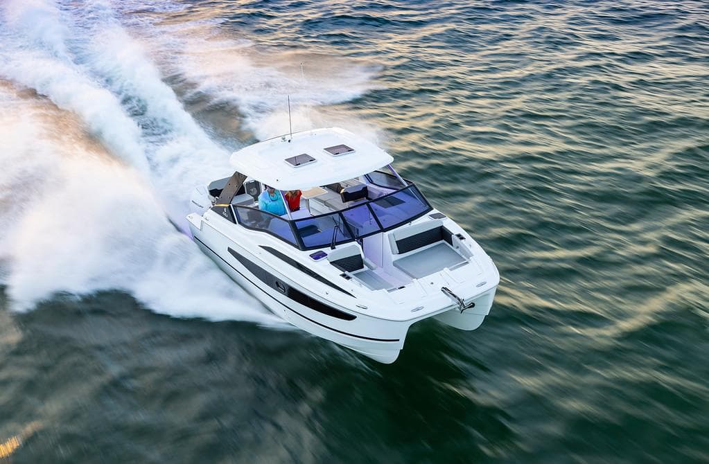 2026 Aquila 32 Sport boat cruising on open water, showcasing sleek design and performance.