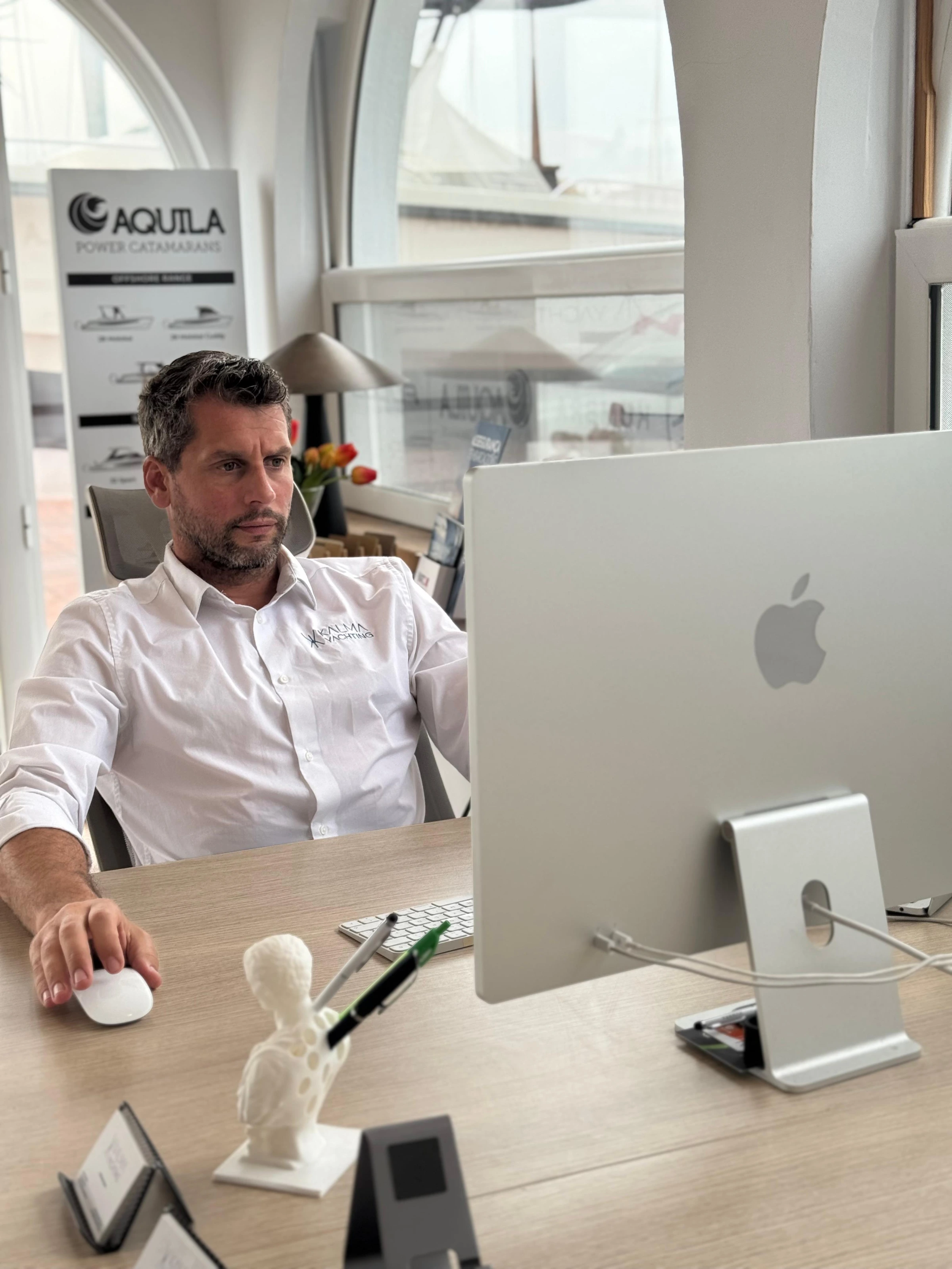 Anthony Kazan at his desk, with the Aquila display behind