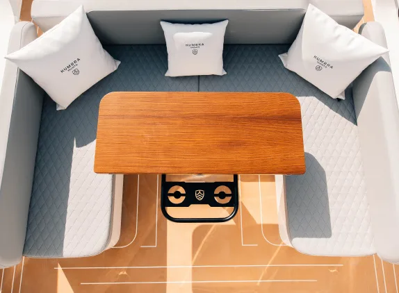 U-shaped dining area with wooden table in the Kumbra 34 cockpit