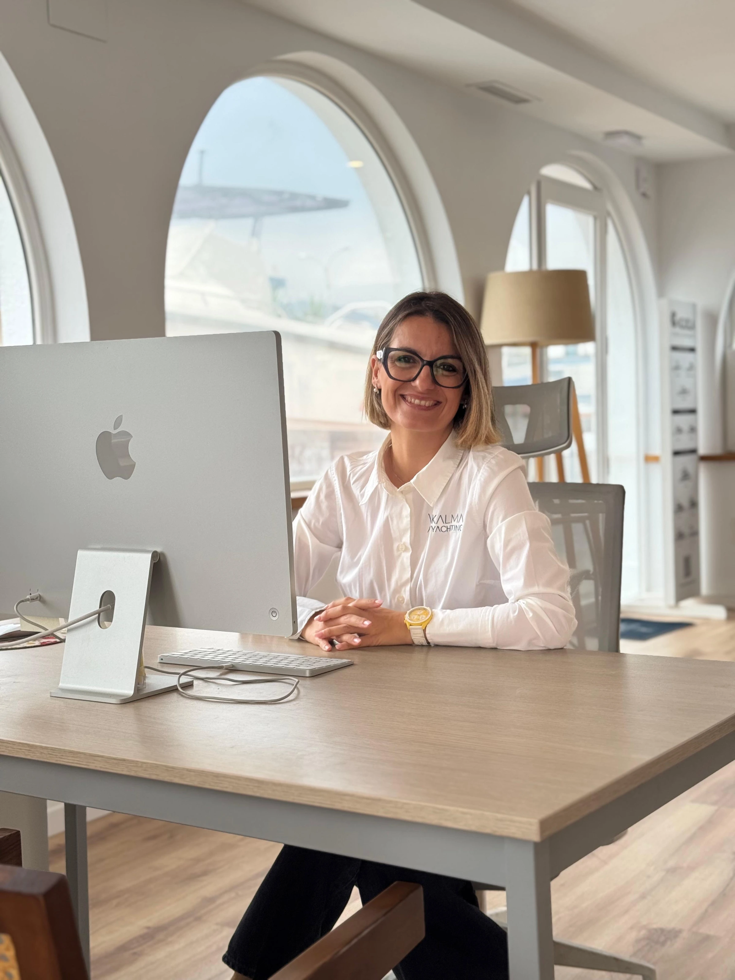 Aída at her desk by the arched windows